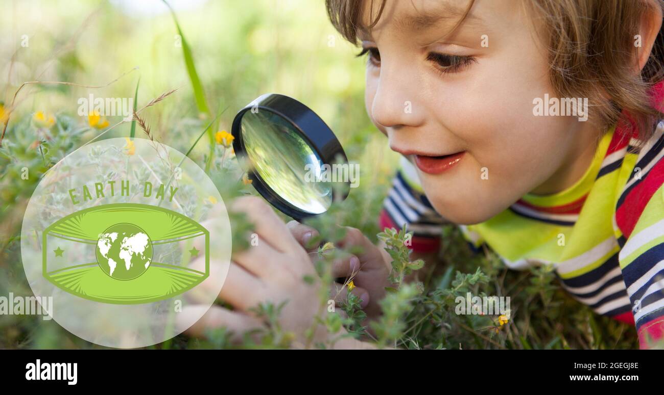 Komposition von Green Globe Logo und Erde Tag Text über Junge mit Lupe in der Natur Stockfoto