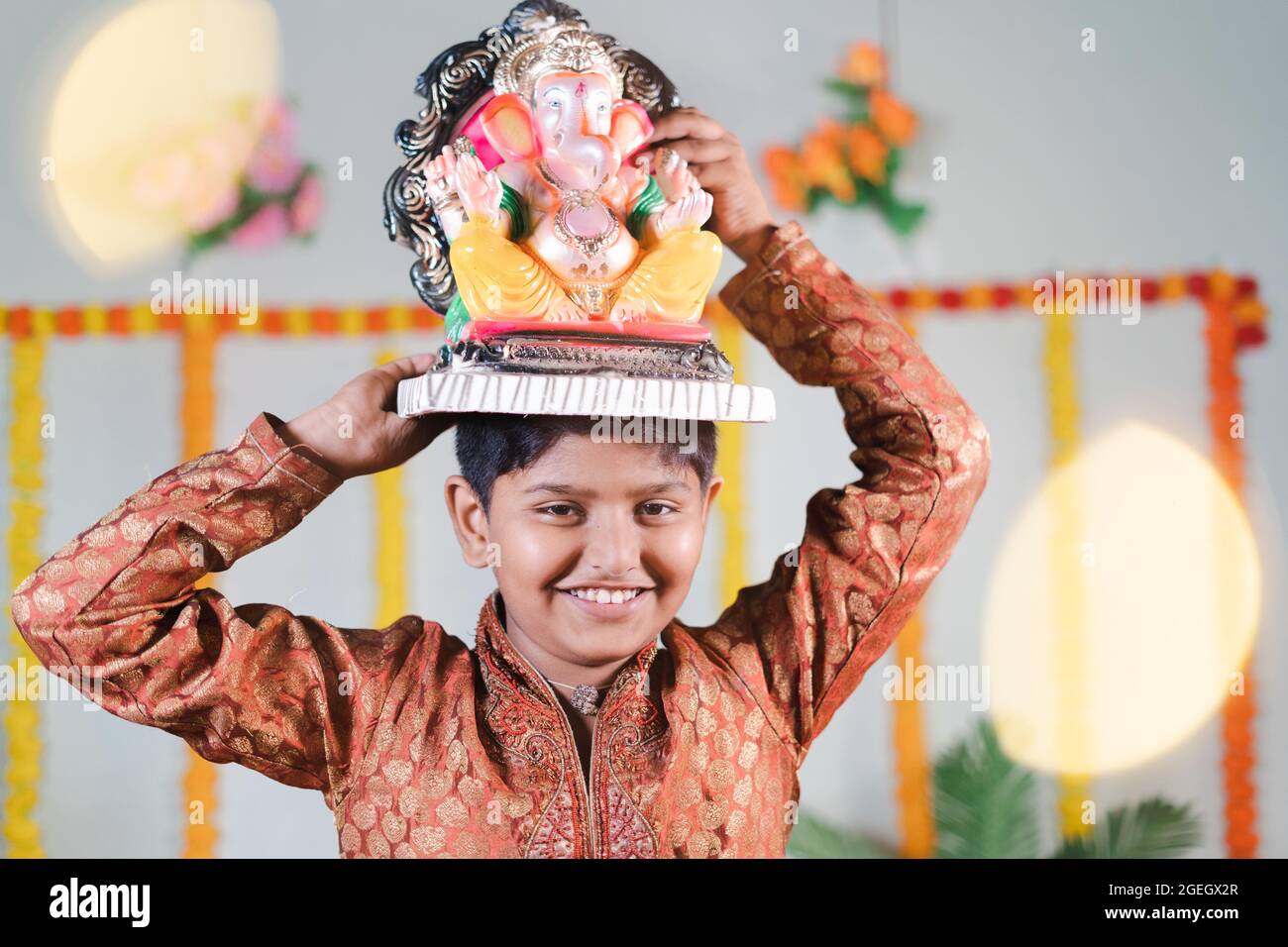 Fröhliches lächelndes Kind während des ganesha-Festivals mit traditioneller Kleidung, die Lord vinayaka für Visarjan oder Immersion während der religiösen Feier trägt Stockfoto