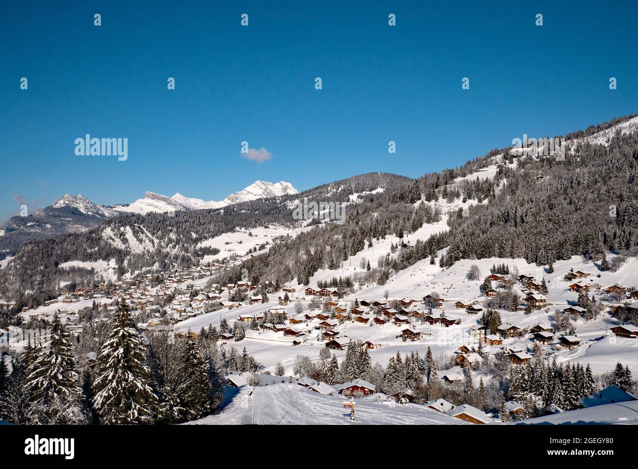 La Clusaz (Alpen, Mittelostfrankreich): Berglandschaft mit schneebedeckten Chalets im Skigebiet, von der Straße zum pa betrachtet Stockfoto