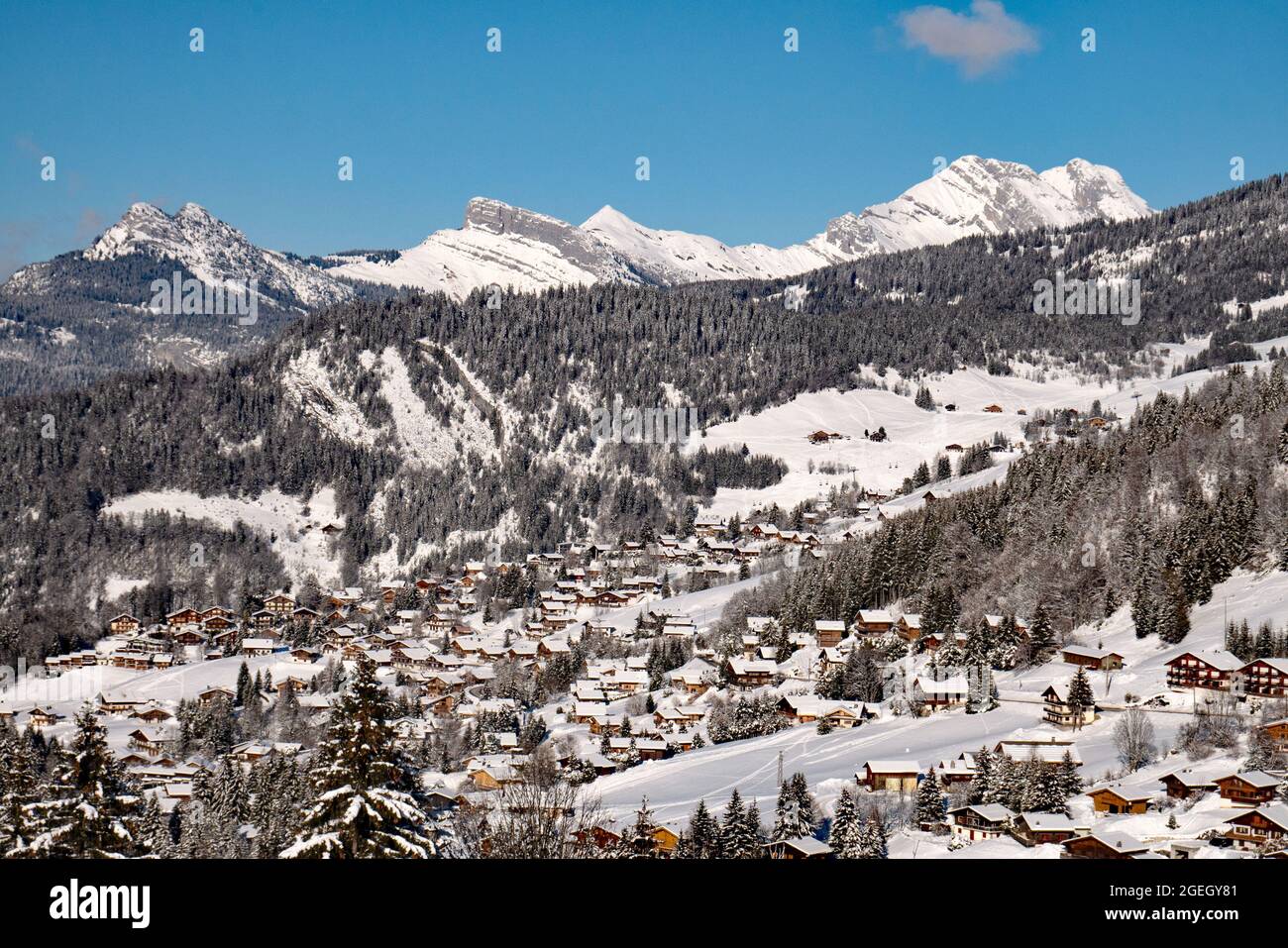 La Clusaz (Alpen, Mittelostfrankreich): Berglandschaft mit schneebedeckten Chalets im Skigebiet, von der Straße zum pa betrachtet Stockfoto