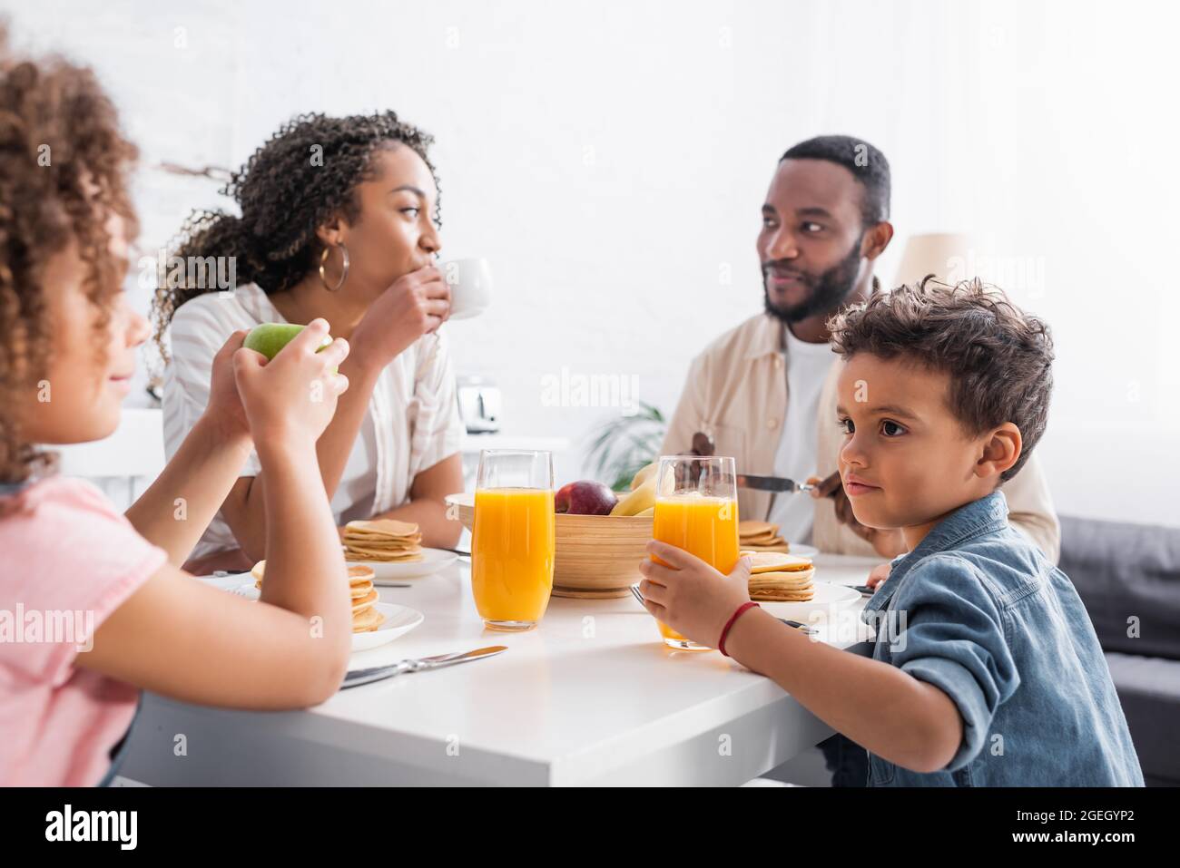 afroamerikanische Frau, die beim Frühstück mit der Familie Kaffee trinkt Stockfoto