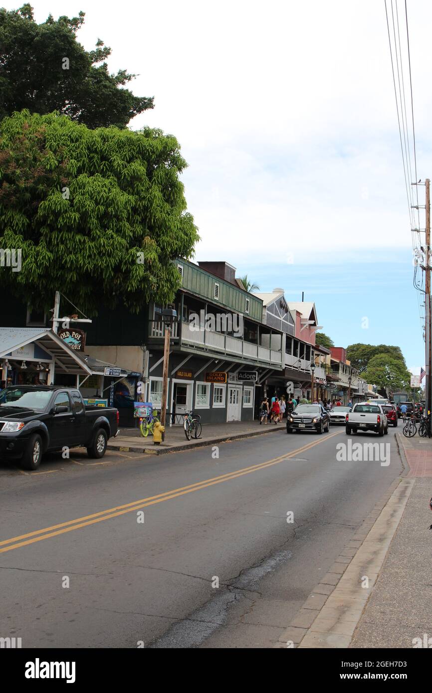 Eine belebte Straße in Lahaina, Maui, gesäumt von Geschäften mit Touristen zu Fuß und Autos fahren in Hawaii, USA Stockfoto