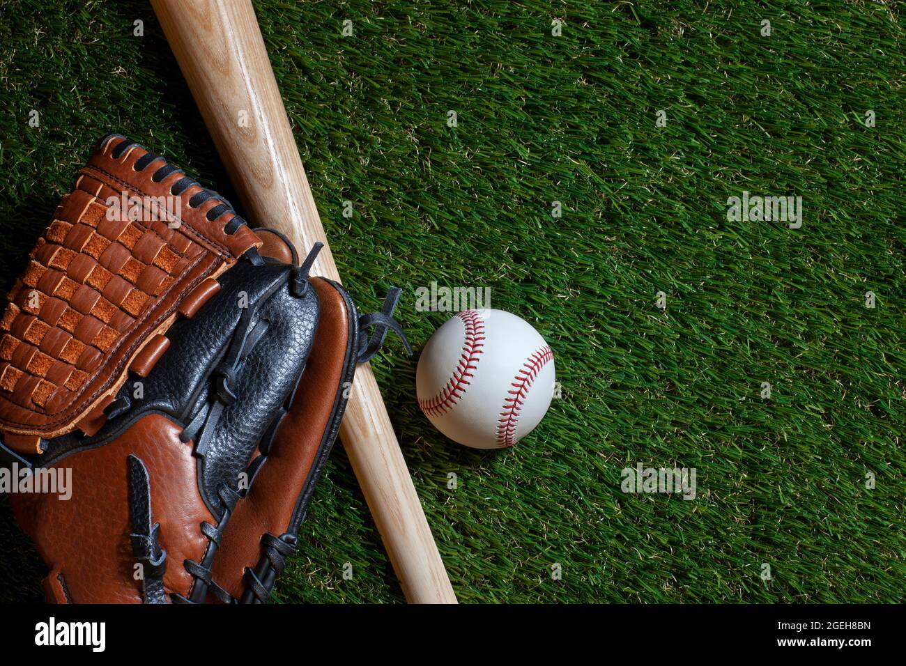 Baseballschläger und Holzschläger mit Fäustling auf dem Grasfeld von oben Stockfoto