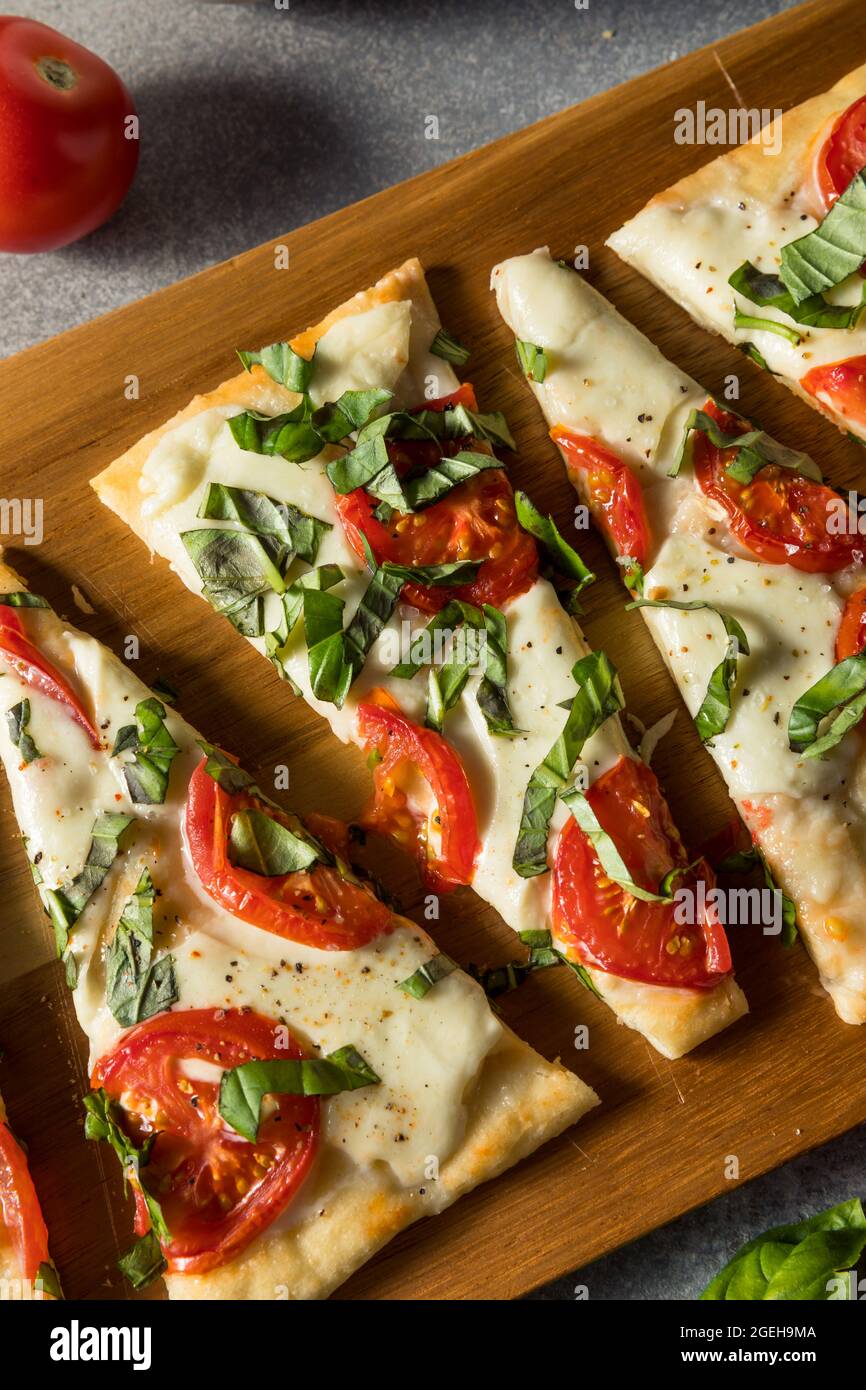 Hausgemachte gesunde Margherita Fladenbrot Pizza mit Basilikum und Tomaten Stockfoto