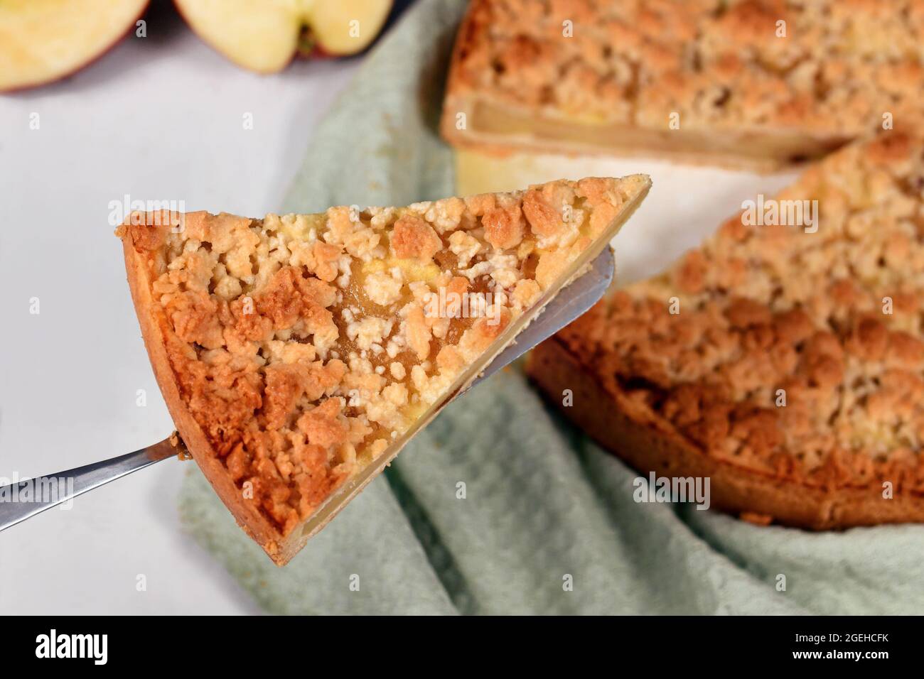 Ein Stück traditioneller europäischer Apfelkuchen mit Topping Crumbles namens „Streusel“ auf dem Kuchenserver Stockfoto