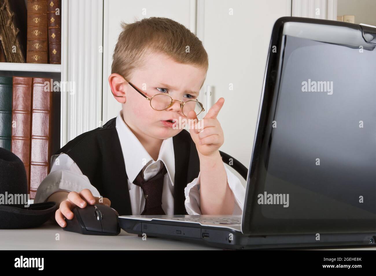 Der vierjährige Chef spielt Regisseur und schaut auf seinen Computerbildschirm Stockfoto