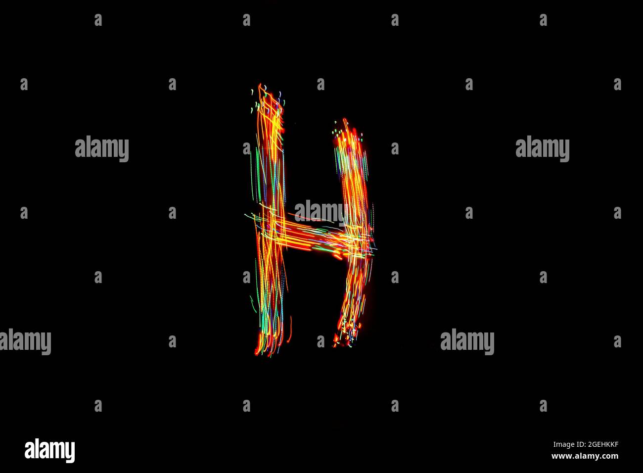 Buchstabe H. Licht Malerei Alphabet. Langzeitbelichtung. Zeichnungsbuchstabe H mit bunten Lichtern auf schwarzem Hintergrund. Stockfoto