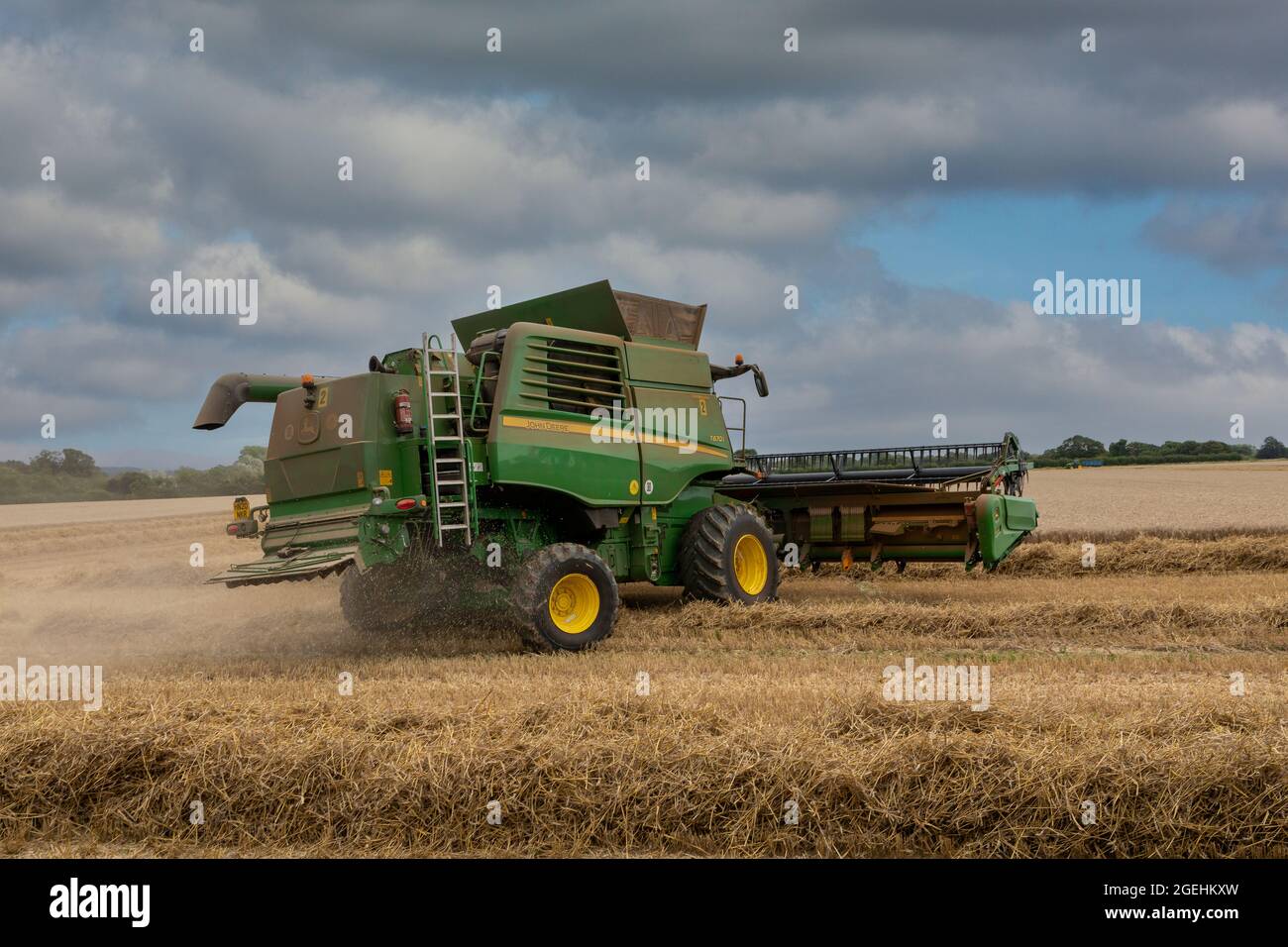 John Deere kombinieren Harvester, um ein Weizenfeld im Süden Englands leicht zu bearbeiten. Stockfoto