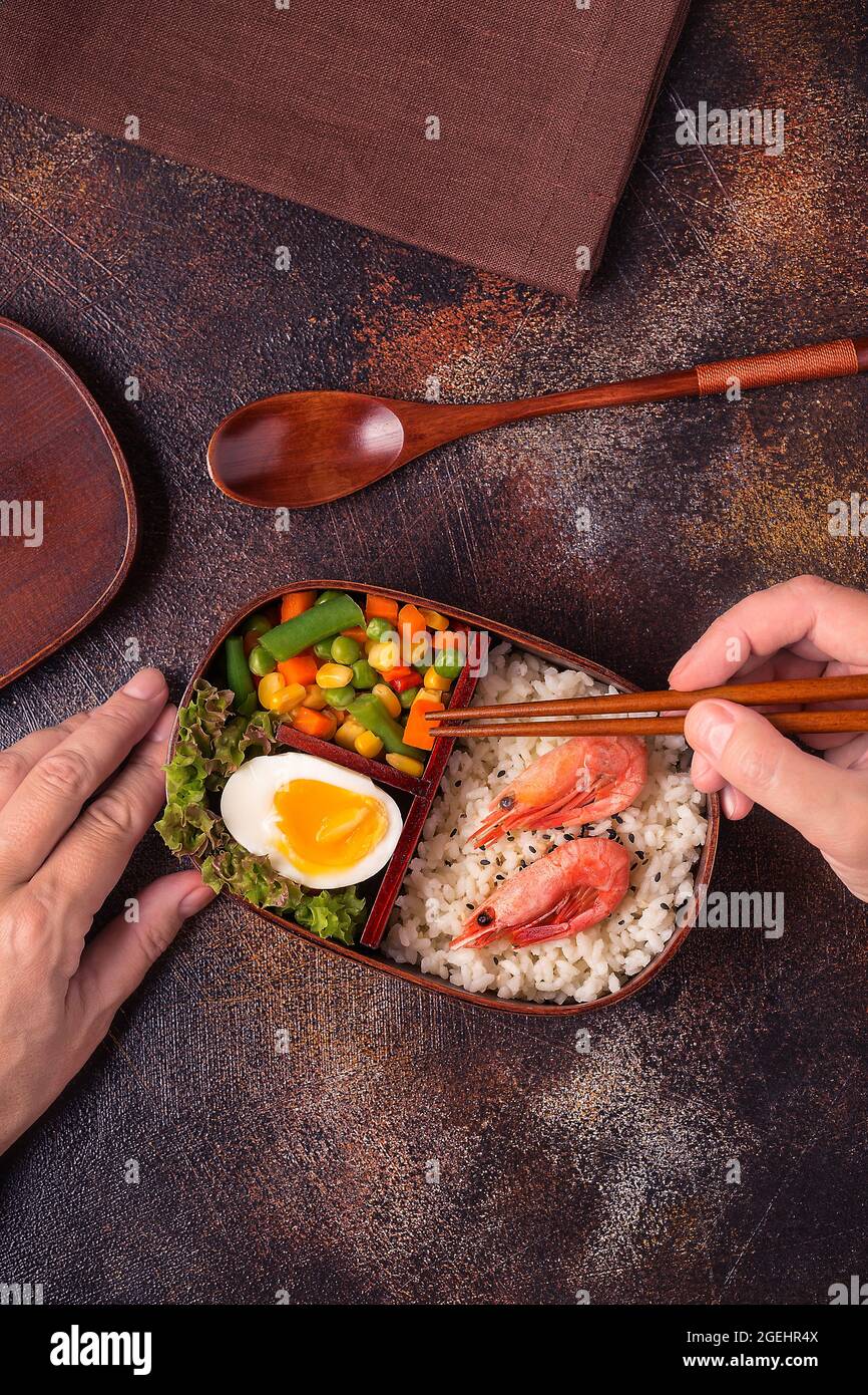 Gesundes Mittagessen in hölzerner japanischer Bento-Box. Ausgewogene gesunde Ernährung Konzept Stockfoto