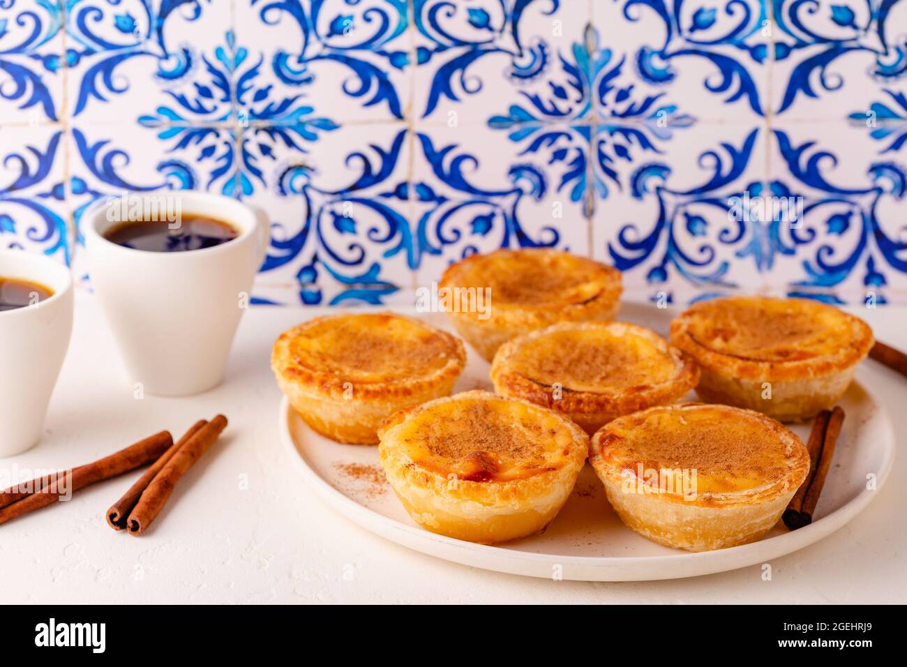 Eiertarte, traditionelles portugiesisches Dessert, Pastell de nata/Pastell de belem. Hintergrund der Azulejo-Kachel. Stockfoto