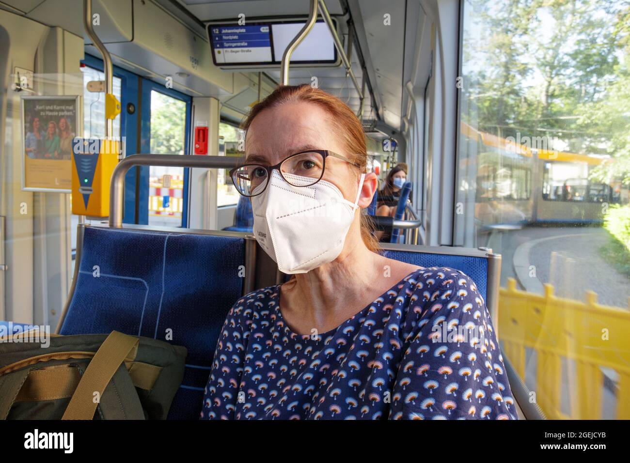 Leipzig, Deutschland, 08-14-2021 eine Frau in einer Straßenbahn trägt wegen der Corona-Pandemie einen medizinischen Mund- und Nasenschutz Stockfoto