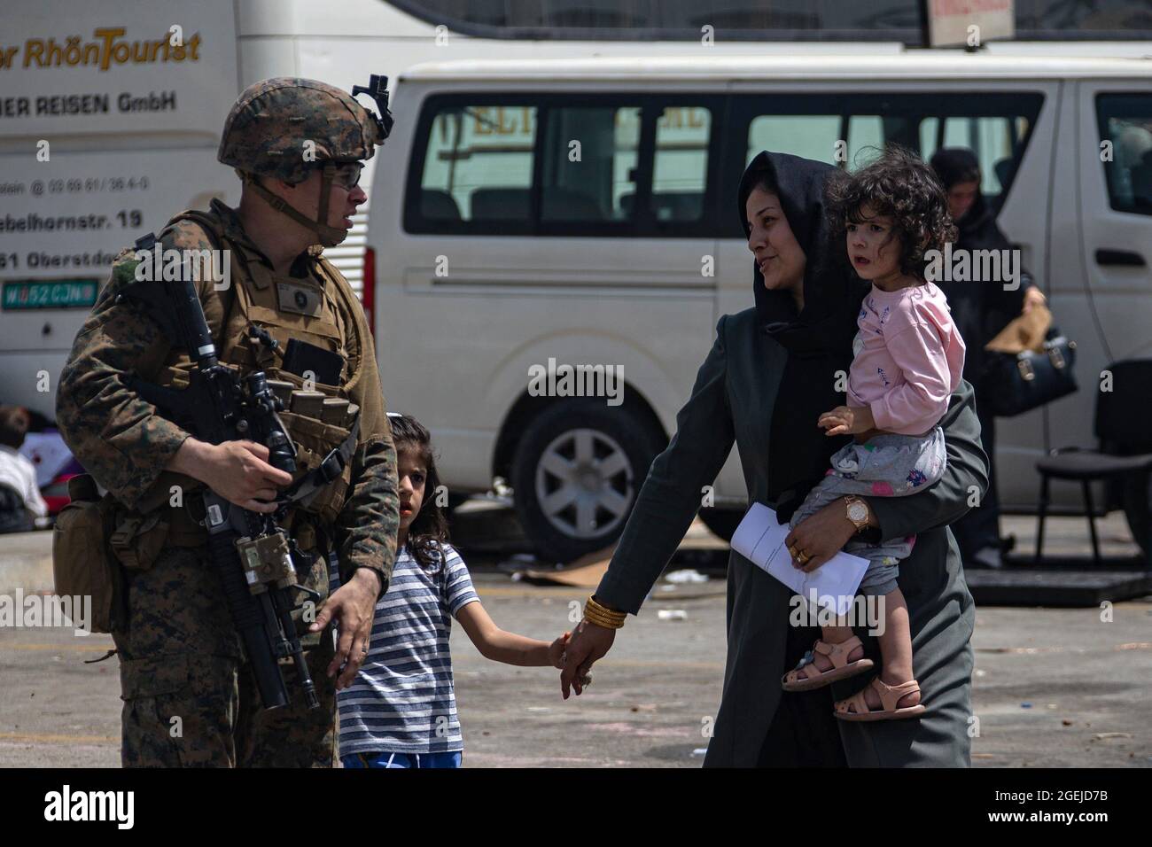 Kabul, Afghanistan. August 2021. Eine Marine, die der 24. Marine Expeditionary Unit zugewiesen ist, begleitet Evakuierte am Hamid Karzai International Airport, Afghanistan, 20. August 2021. US-Dienstmitglieder unterstützen das Außenministerium bei einer nicht-kämpferischen Evakuierungsoperation (NEO) in Afghanistan. Foto von CPL. Davis Harris/USMC/UPI Credit: UPI/Alamy Live News Stockfoto