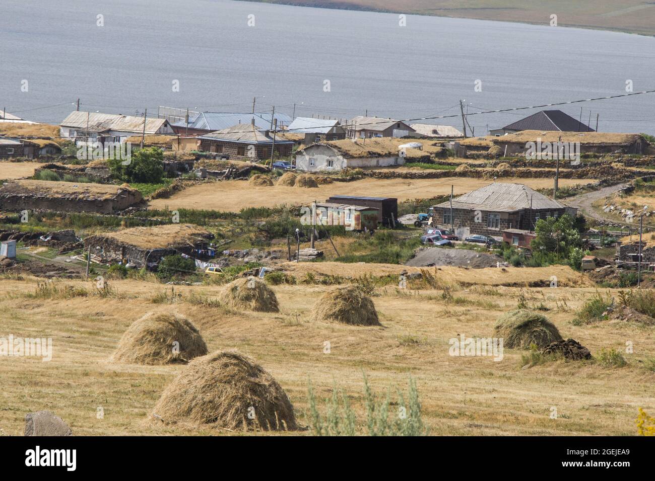 Blick auf Dorfhäuser und einen Bauernhof am Ufer des Sees Paravani, in Javakheti, Georgien Stockfoto