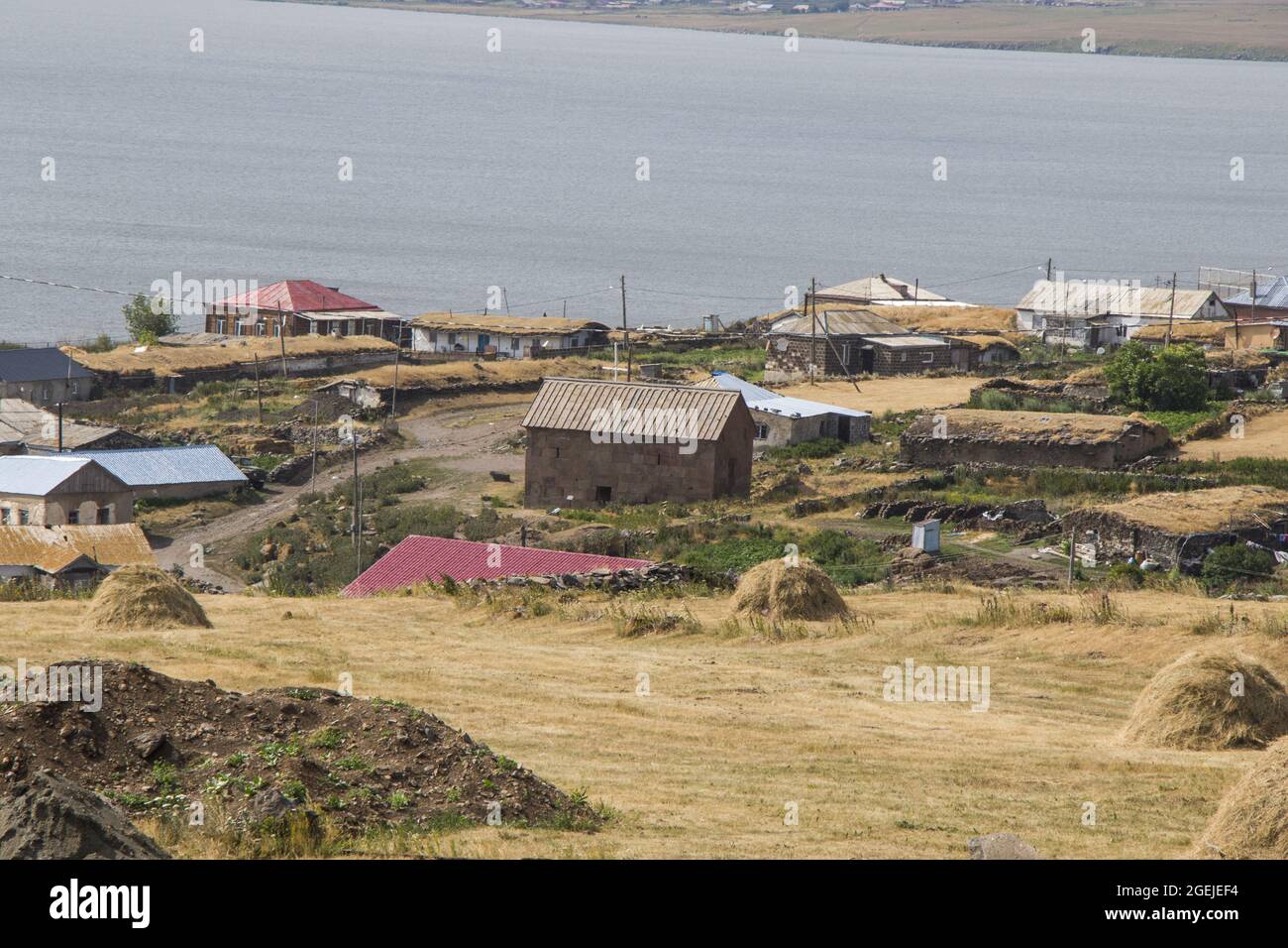 Blick auf Dorfhäuser und einen Bauernhof am Ufer des Sees Paravani, in Javakheti, Georgien Stockfoto