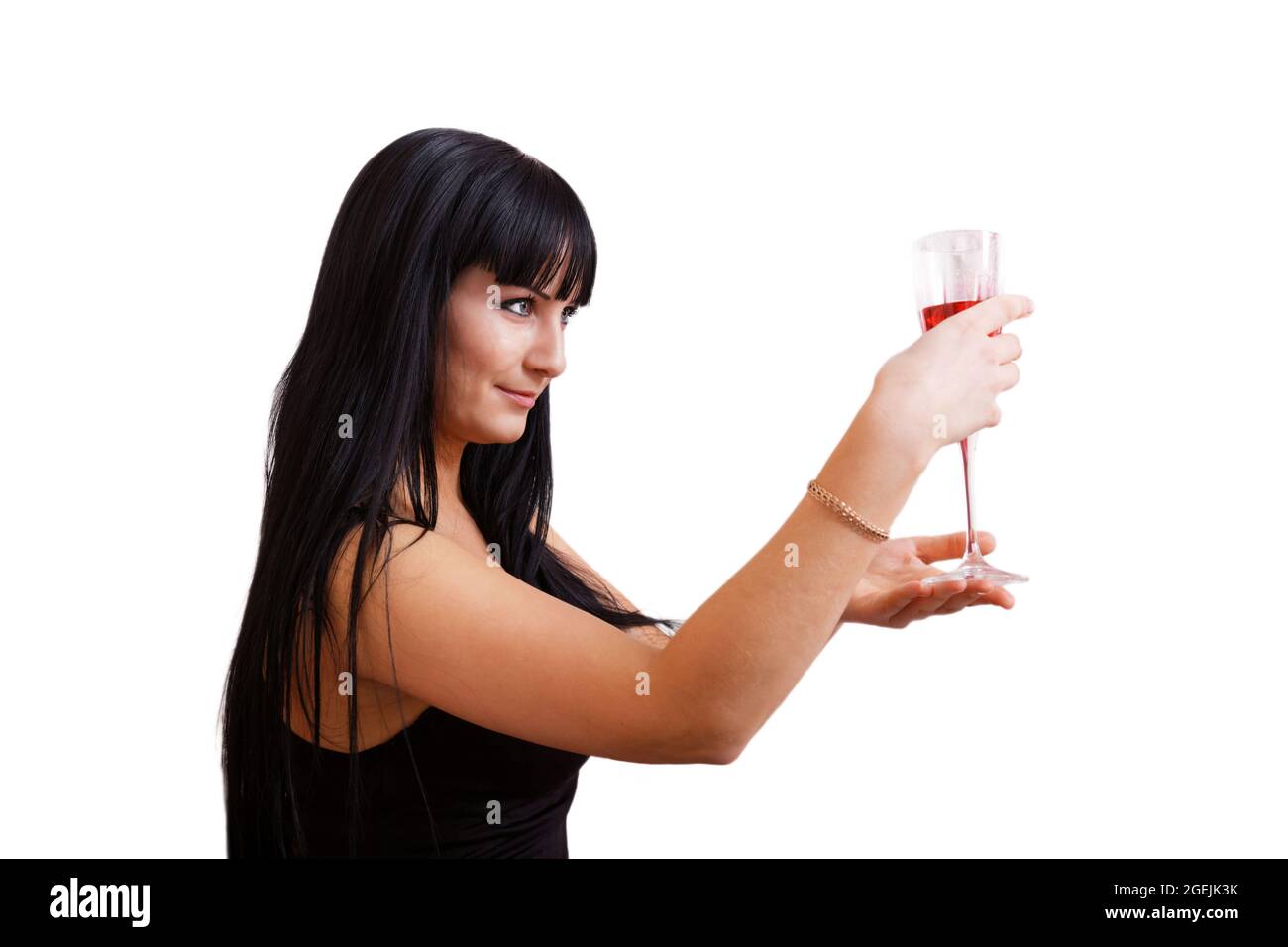 Junge langhaarige Brünette Frau mit einem Glas rosa Wein in den Händen sieht auf dem Weinglas. Isoliert auf Weiß. Stockfoto