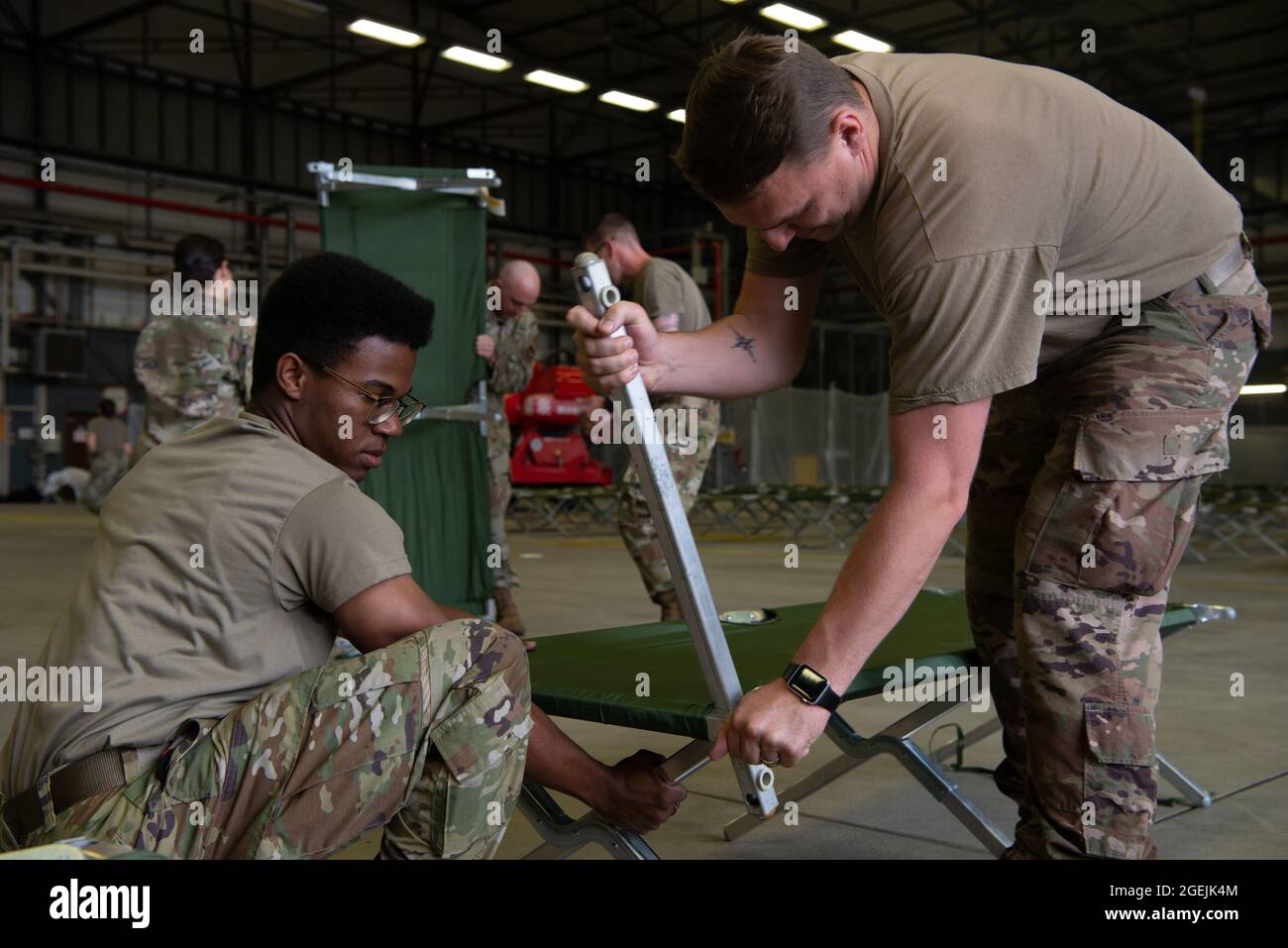 US Air Force Airmen, die der Ramstein Air Base zugewiesen sind, bereiten in einem Hangar auf der Ramstein Air Base, Deutschland, am 19. August 2021 Kinderbetten vor. Der Luftwaffenstützpunkt Ramstein stellt im Rahmen der Operation Allies Refuge in den nächsten Wochen sichere, temporäre Unterkünfte für qualifizierte Evakuierte aus Afghanistan bereit. Die Operation Allies Refuge erleichtert die schnelle und sichere Evakuierung von US-Bürgern, Visa-Antragstellern für Sondereingewanderte und anderen gefährdeten Afghanen aus Afghanistan. Qualifizierte Evakuierte werden Unterstützung erhalten, wie z. B. vorübergehende Unterbringung, Nahrung, medizinische Vorsorgeuntersuchungen und Behandlungen und mehr auf dem Ramstein Air Base während der Vorbereitung f Stockfoto