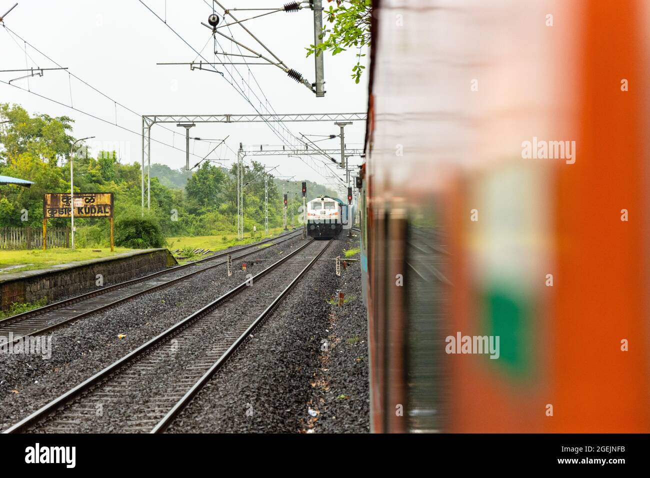 Güterzug Kreuzung am Bahnhof Kudal während der Monsun Saison auf Konkan Railway in Maharashtra, Indien Stockfoto