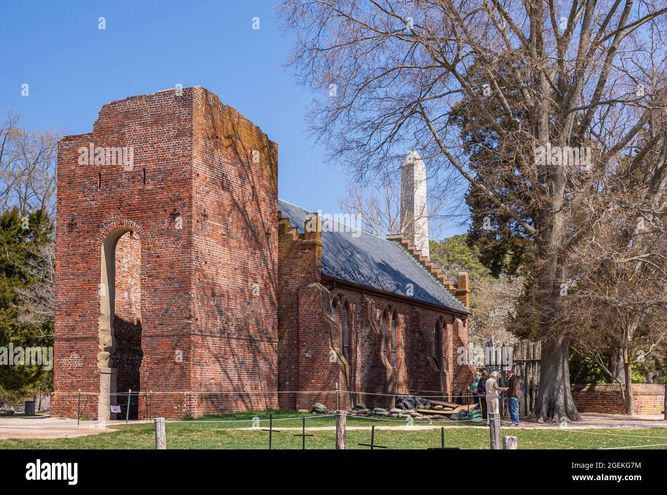 Jamestowne, VA, USA - 1. April 2013: Historische Stätte. Rote Backsteinruine des ursprünglichen Kirchturms mit Kirchenschiff im 20. Jahrhundert gegen blauen Himmel rekonstruiert w Stockfoto
