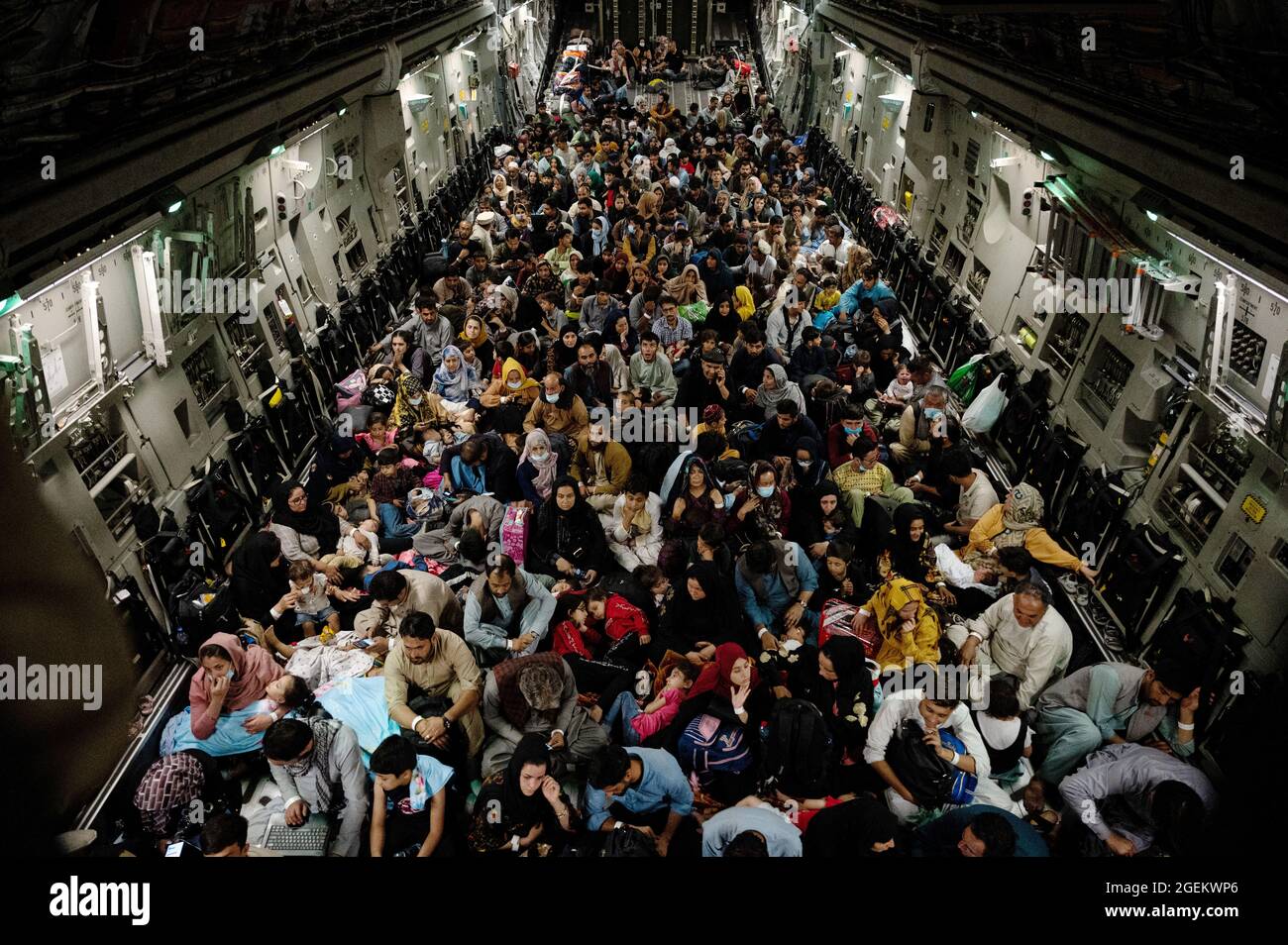 Kabul, Afghanistan. August 2021. Hunderte afghanischer Flüchtlinge sitzen während der Evakuierung von nicht-Kombattanten auf dem Hamid Karzai International Airport im Rahmen der Operation Allies Refuge am 19. August 2021 in Kabul, Afghanistan, auf dem Boden eines Flugzeugs der US-Luftwaffe C-17 Globemaster III. Quelle: Planetpix/Alamy Live News Stockfoto