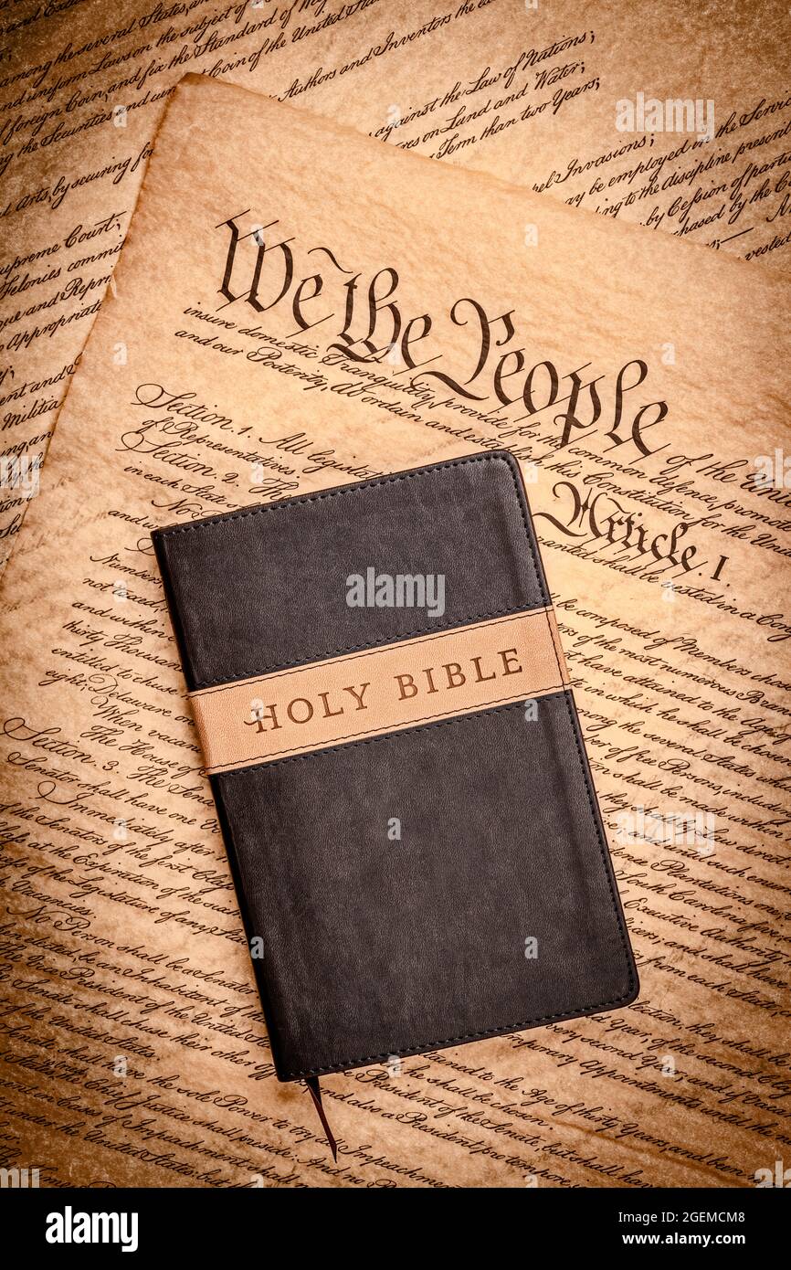 Eine heilige bibel und ein kleines Kreuz ruhen auf der Verfassung der Vereinigten Staaten, die für die Religionsfreiheit ohne Verfolgung steht. Stockfoto