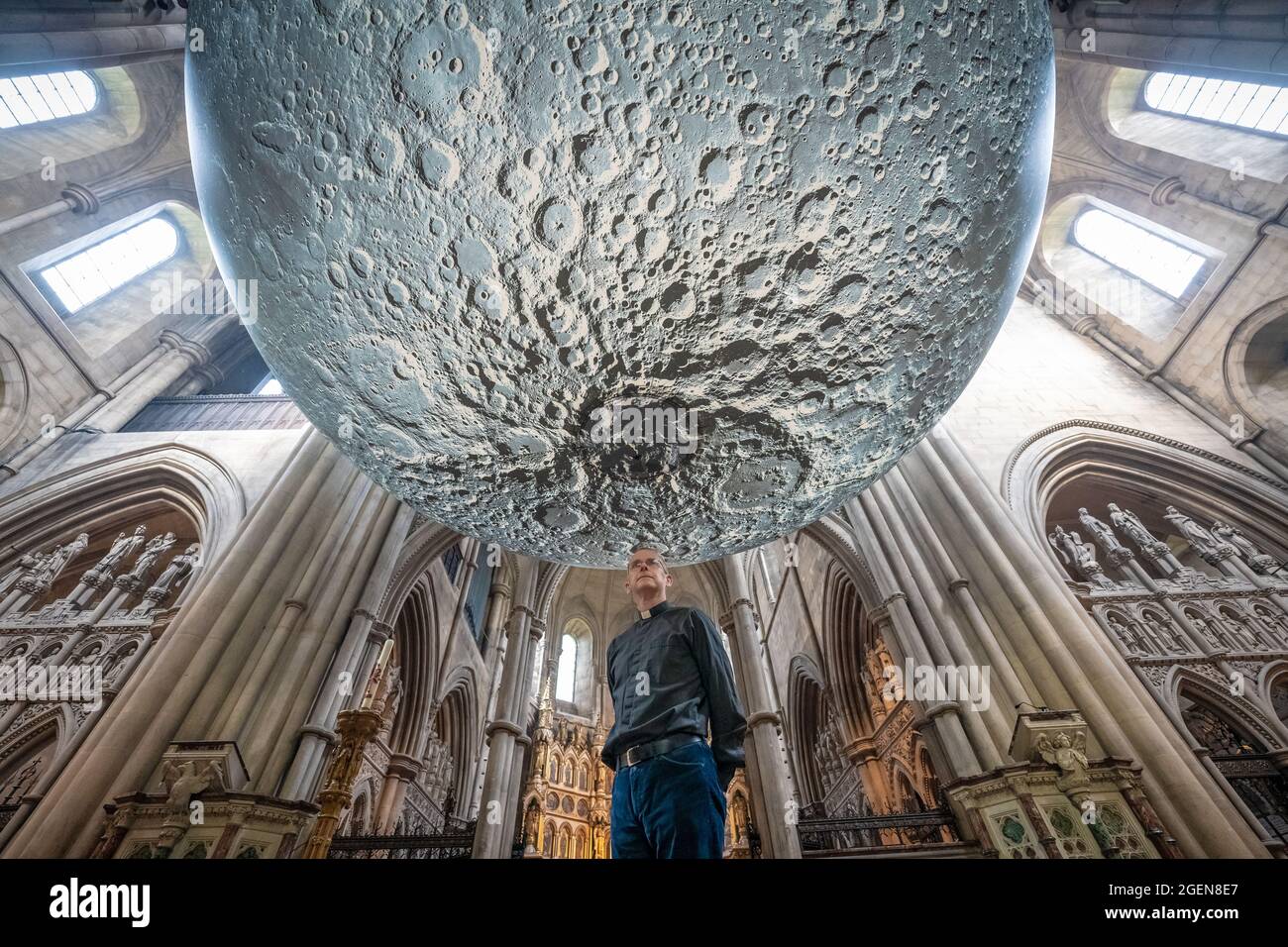 Der Resident Vicar, James Heard, steht mit der Installation des Museum of the Moon des Künstlers Luke Jerram in der St. John the Baptist Kirche im Westen Londons, Großbritannien. Stockfoto