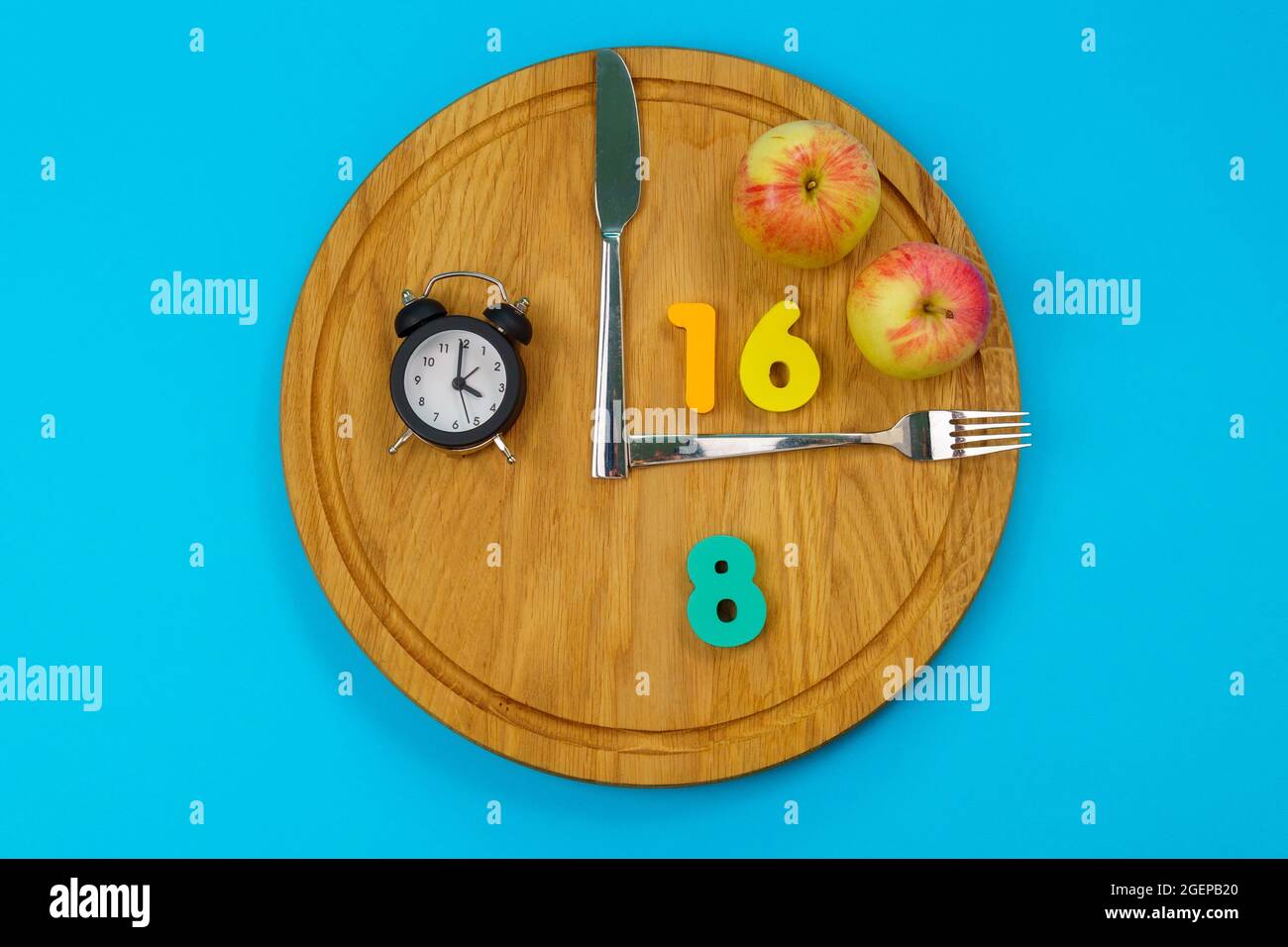 Intermittierendes Fastenkonzept 16:8. Intermittierendes Fasten wird häufig zum Abnehmen oder zur Kontrolle von Diabetes eingesetzt. Blauer Hintergrund Stockfoto