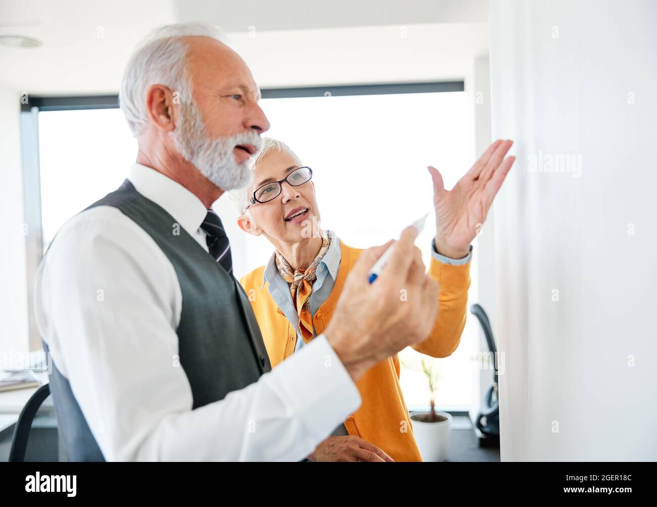 Senior Business Mann Frau Büro Whiteboard Präsentation Team Kollegen arbeiten Stockfoto