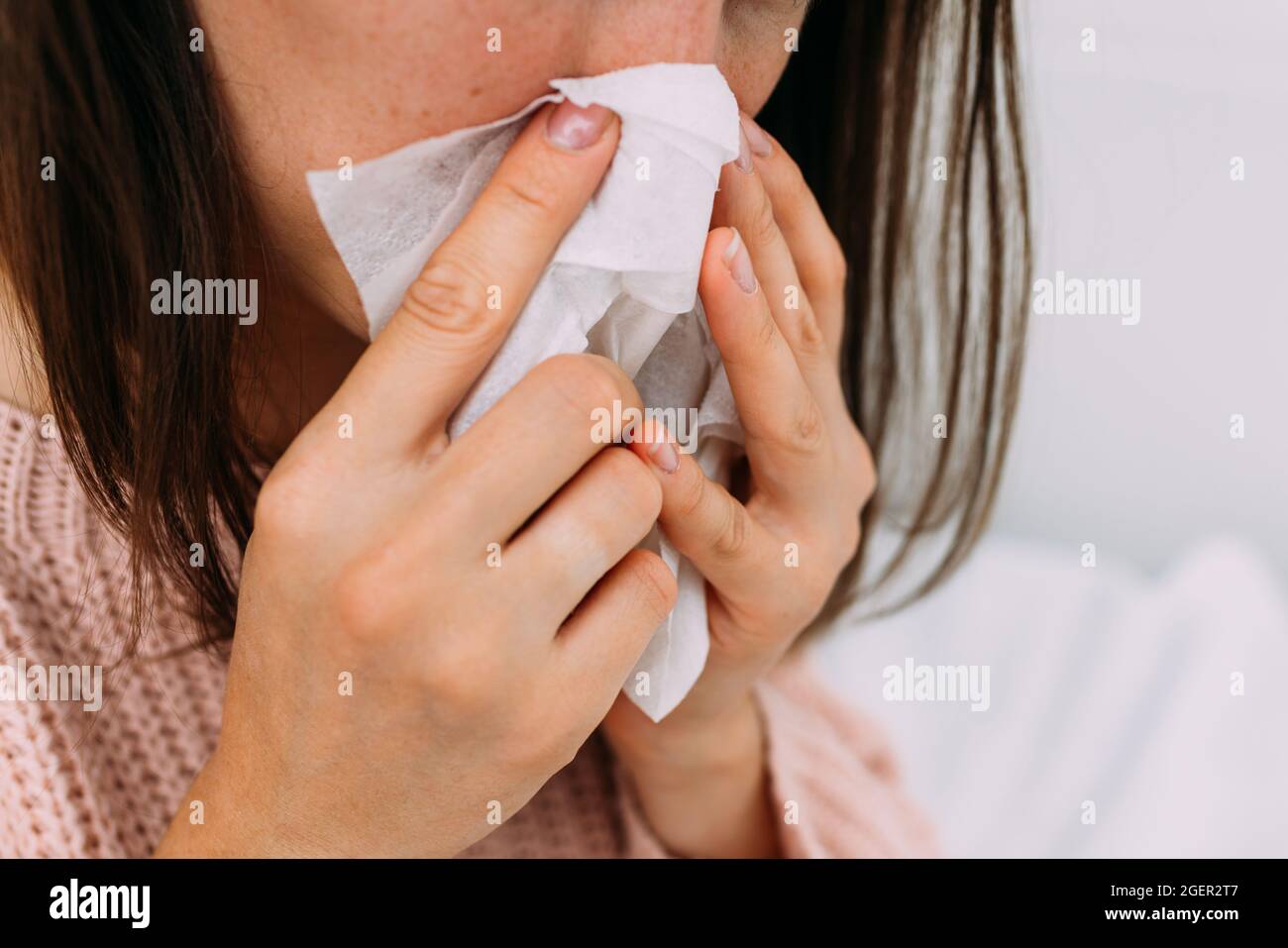 Der Mensch hat eine Erkältung und bläst seine Nase in eine Serviette Stockfoto