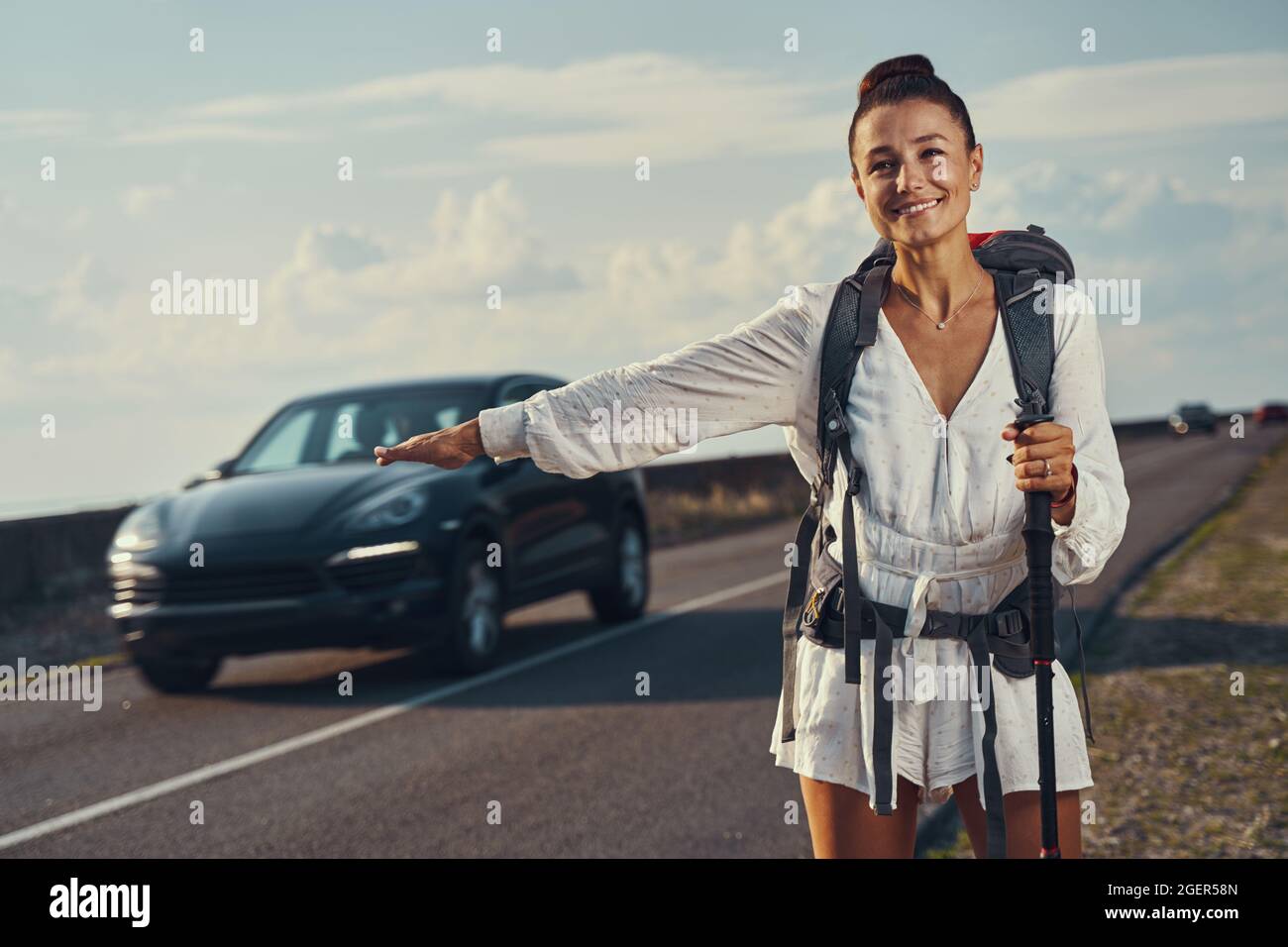 Reisender bittet das Auto, mit Handbewegung anzuhalten Stockfoto Reisender bittet das Auto, mit Handbewegung anzuhalten Stockfoto