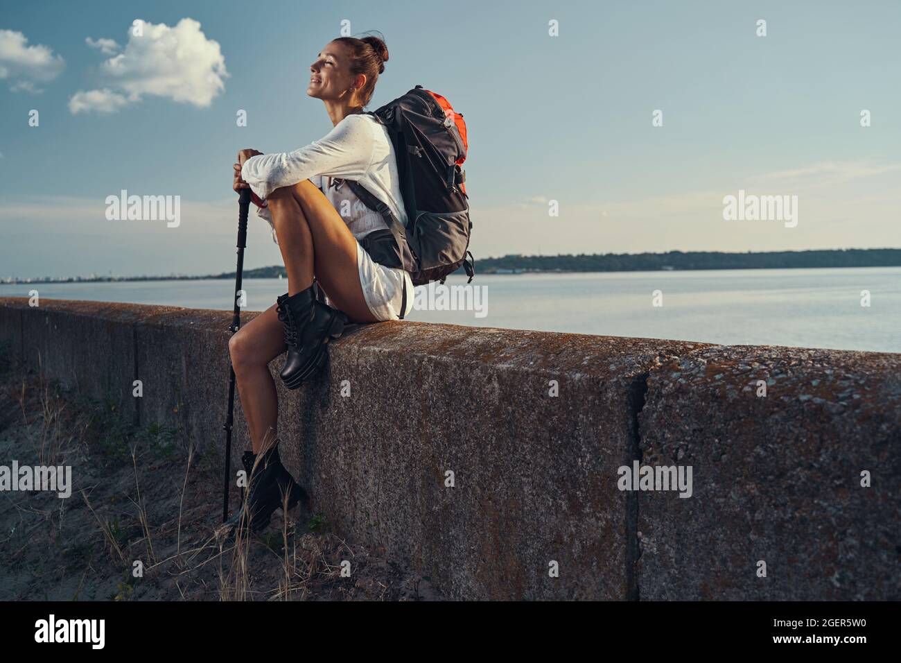 Wanderer genießen Sonnenstrahlen, während sie auf einem Steinkandstein sitzen Stockfoto Wanderer genießen Sonnenstrahlen, während sie auf einem Steinkandstein sitzen Stockfoto