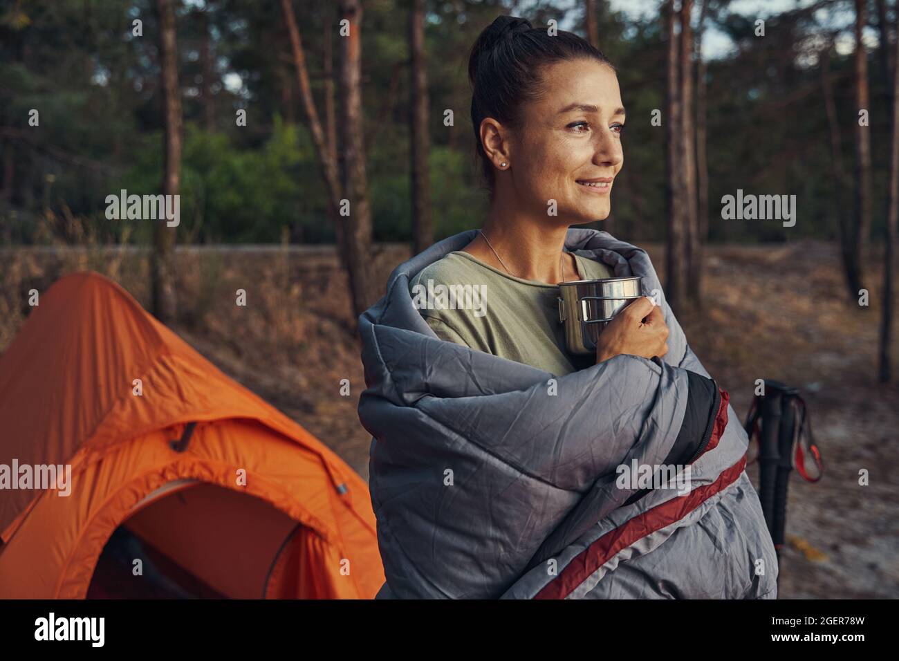 Camper in graue Abdeckung gewickelt und hält Tee Stockfoto Camper in graue Abdeckung gewickelt und hält Tee Stockfoto