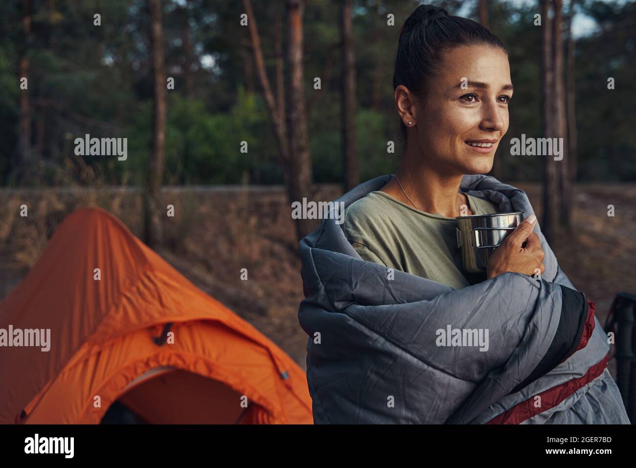 Weibchen im Wald mit kuscheliger Decke auf ihren Schultern Stockfoto Weibchen im Wald mit kuscheliger Decke auf ihren Schultern Stockfoto