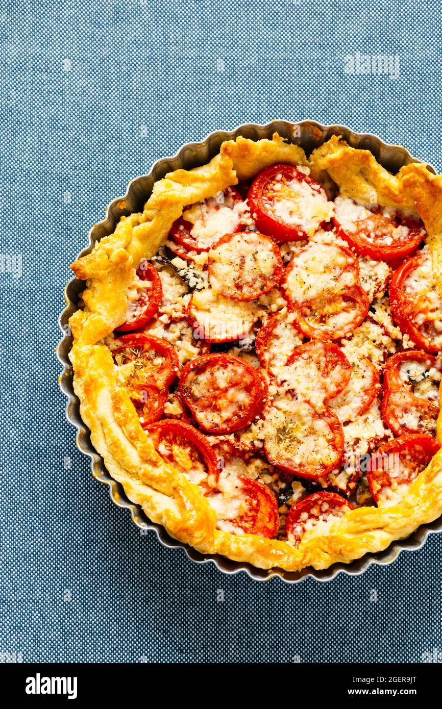 Quiche mit Tomaten und Käse auf schlichem Hintergrund Stockfoto