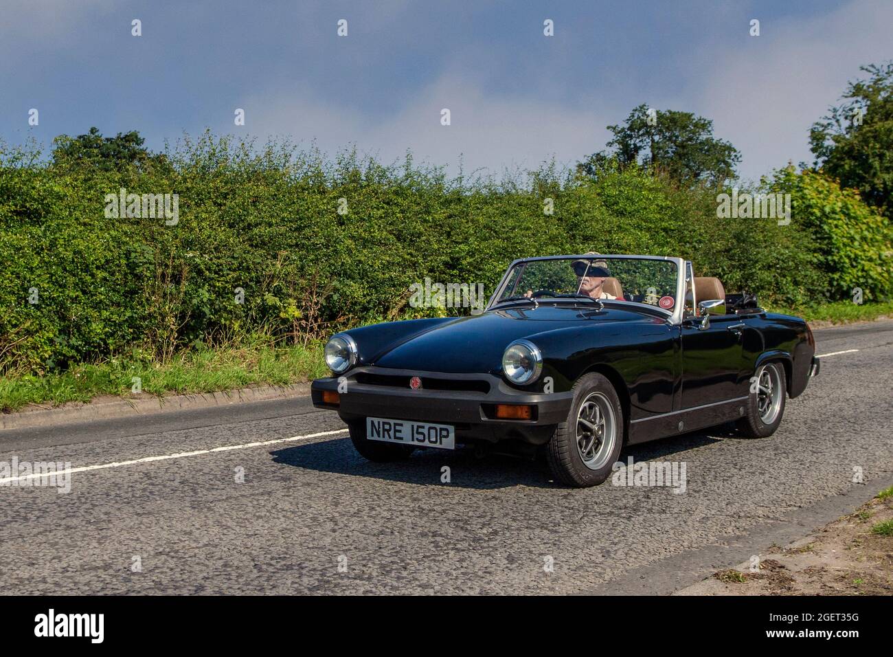 1976 70er Jahre schwarzes MG Midget 1491 ccm Benzin-Cabrio, auf dem Weg zur Capesthorne Hall classic July Car Show, Ceshire, Großbritannien Stockfoto