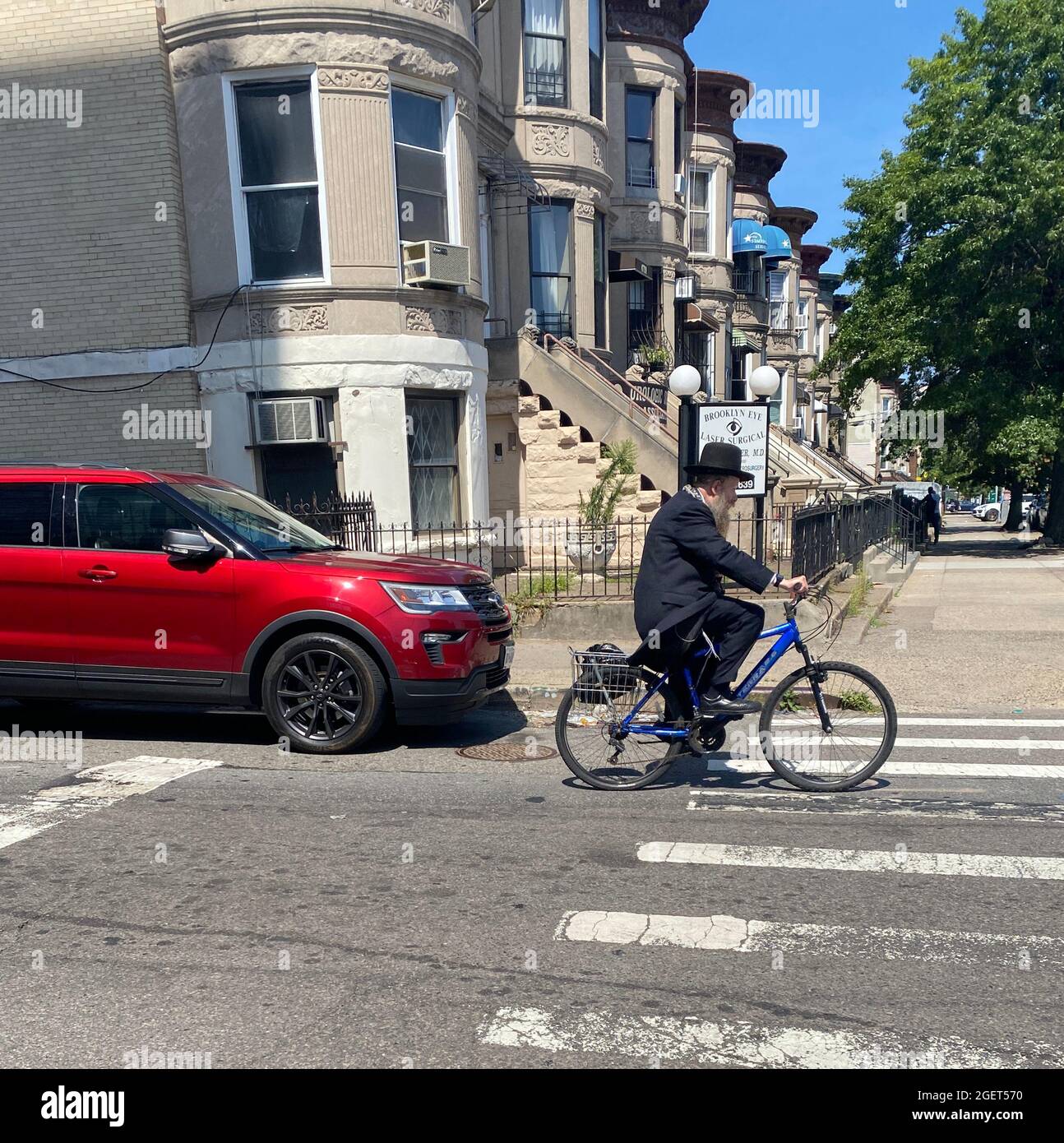 Älterer orthodoxer jüdischer Mann fährt im Stadtteil Borough Park in Brooklyn, New York, mit dem Fahrrad. Stockfoto