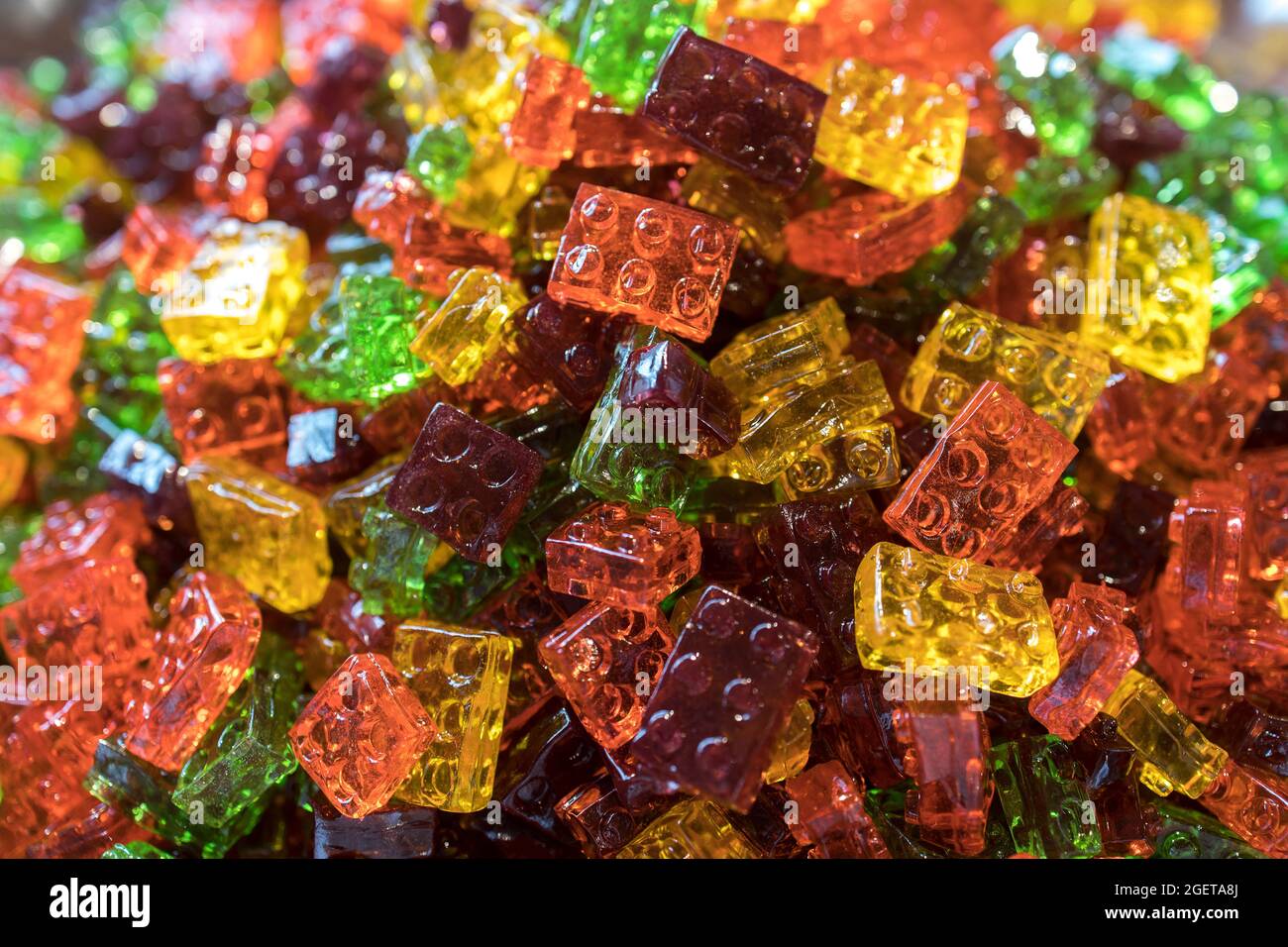 Süße Gummiknüppel, mehrfarbige Stäbchen in Form von lego auf einem Kirmes-Stand im Stapel Stockfoto