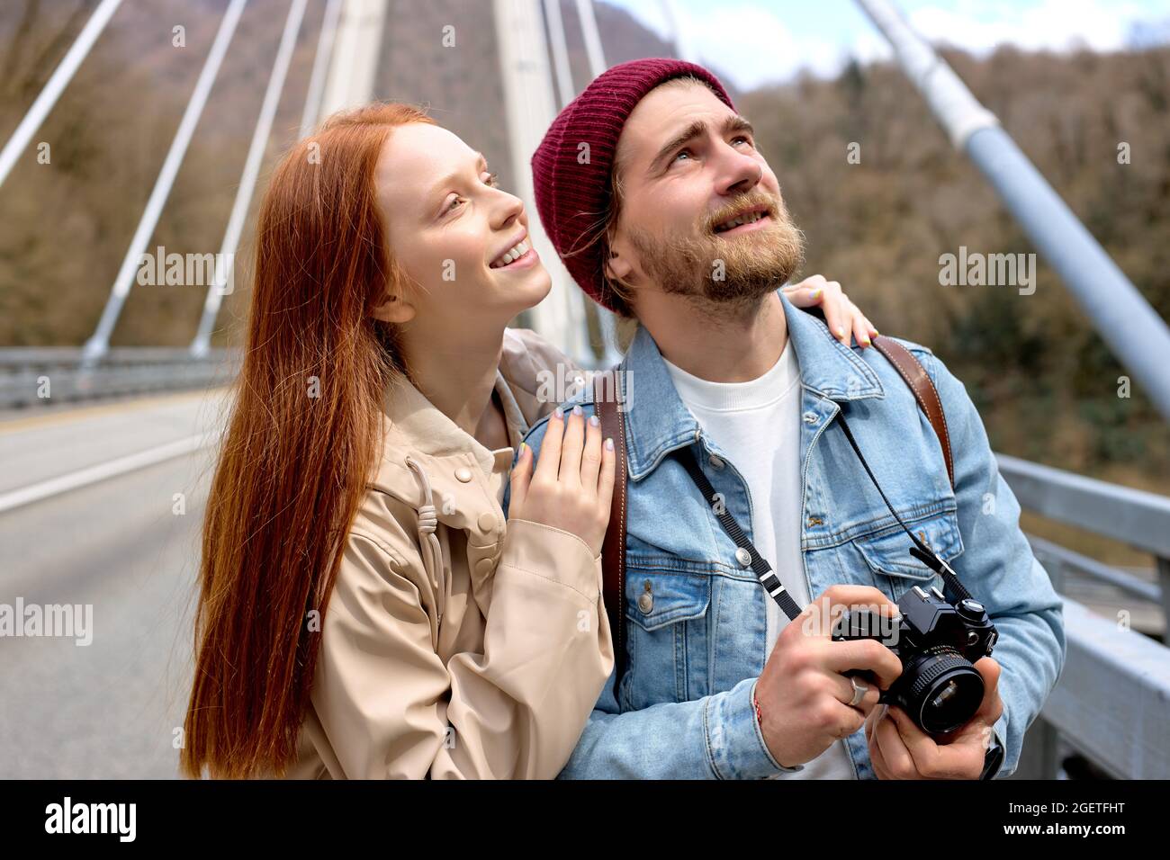 Outdoor-Porträt eines kaukasischen Paares in lässigen warmen Outfits, das in der kalten Jahreszeit im Frühling auf der Brücke spazieren geht, nach oben schaut und Platz kopiert. Urbane Lebensart Stockfoto Outdoor-Porträt eines kaukasischen Paares in lässigen warmen Outfits, das in der kalten Jahreszeit im Frühling auf der Brücke spazieren geht, nach oben schaut und Platz kopiert. Urbane Lebensart Stockfoto