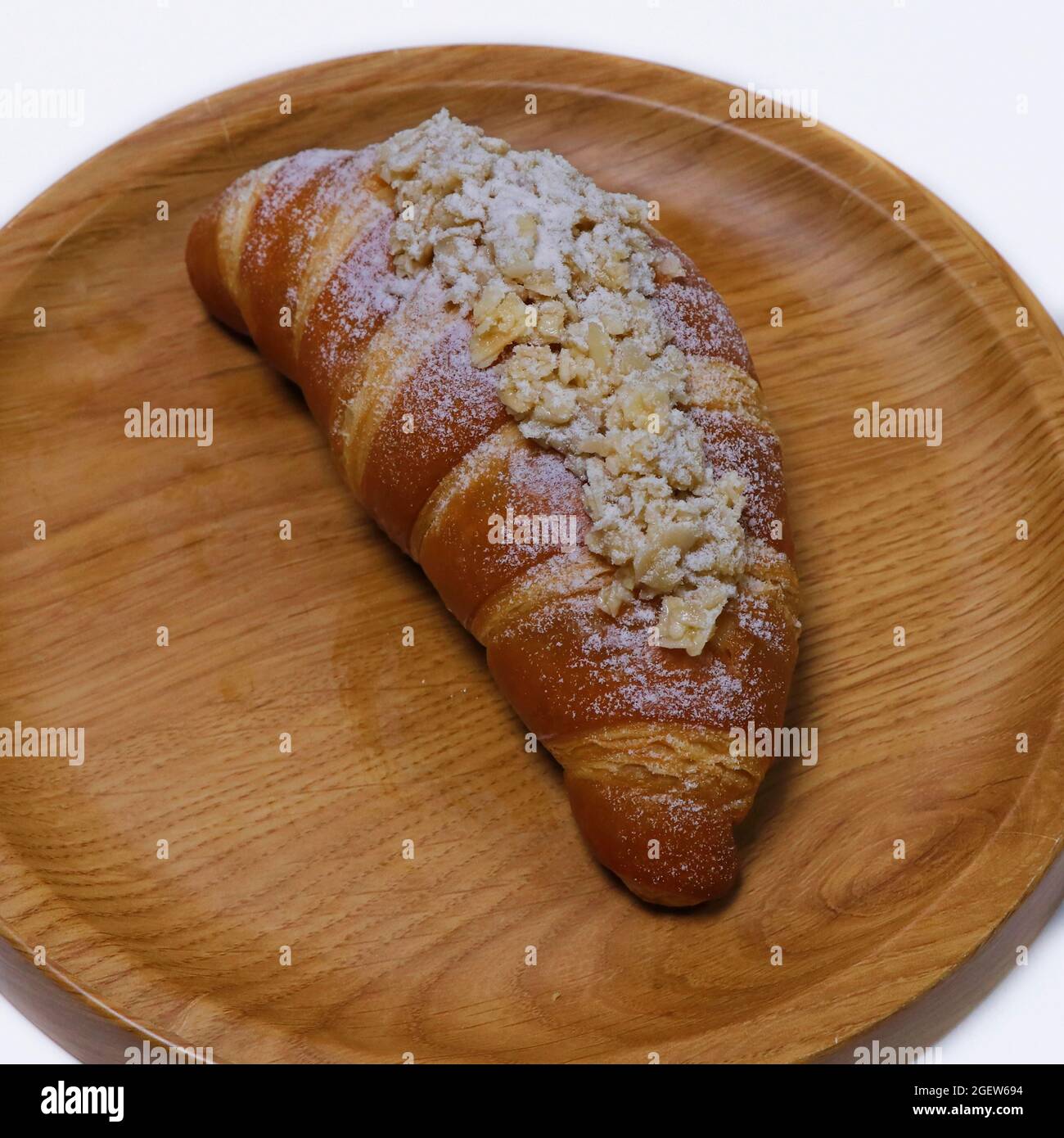 Mandelcroissant französisches Gebäck in einem Holzbrett Stockfoto