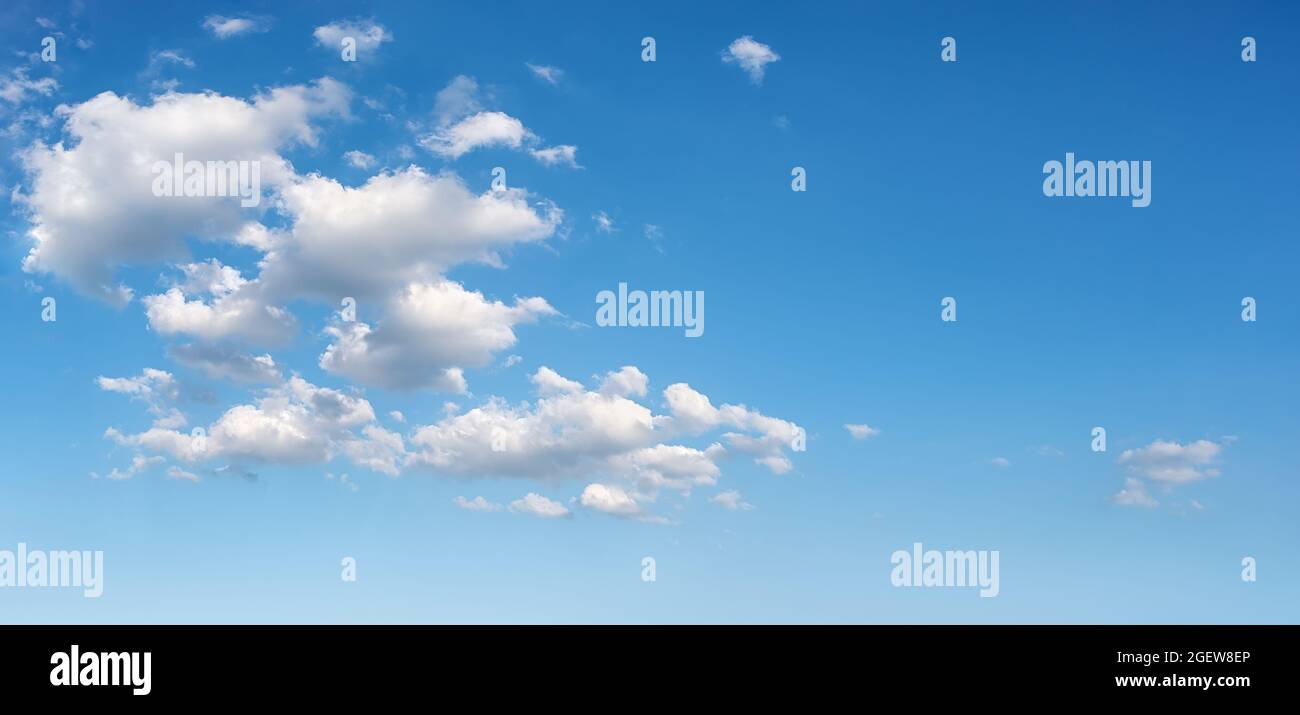 Schöner Frühlingshimmel mit einigen weißen, flauschigen Wolken an einem sonnigen Tag. Klarer, strahlend blauer Sommerhimmel für Wetterprognosen, Urlaube und Ideen zur Reisezeit Stockfoto