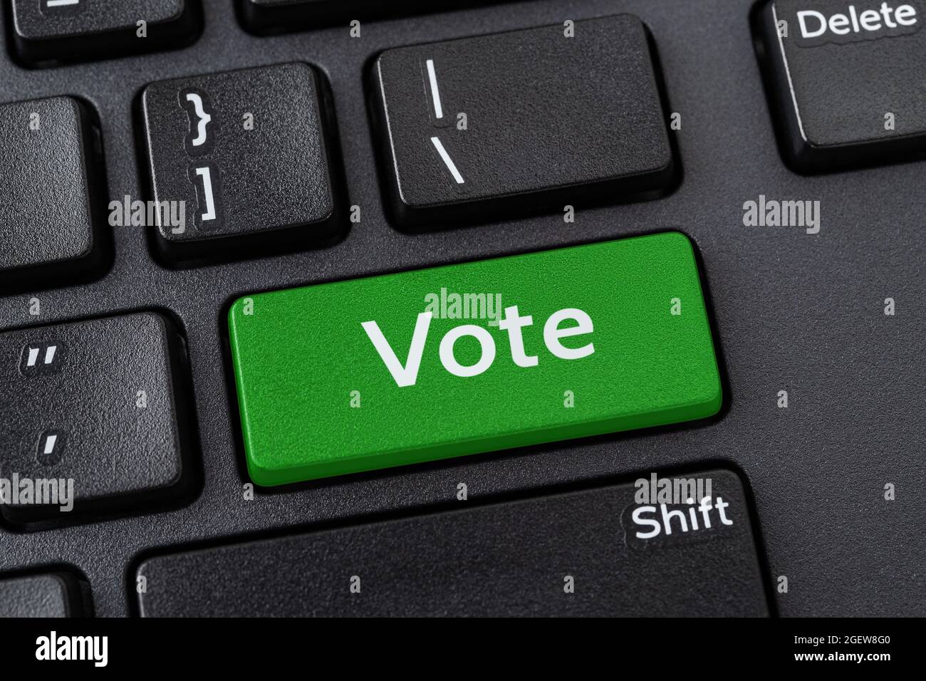 Abstimmtaste auf einer schwarzen pc-Tastatur. Online-Wahlbeteiligung, Internet-Voting und E-Voting-Konzepte. Computer Notebook Schlüssel mit Abstimmwort eingeben. Stockfoto