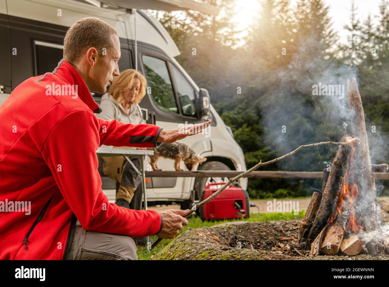 Moderne Freizeitfahrzeuge Thema. Wochenende RV Camping Kurzurlaub. Kaukasische Freunde vor einem Lagerfeuer. Road Trip und das Van Life. Stockfoto