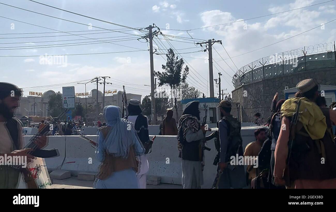 Kabul, Afghanistan. August 2021. Taliban-Kämpfer stehen Wache, als sich Afghanen am Samstag, den 21. August, vor dem Hamid Karzai International Airport versammeln, um aus dem Land zu fliehen. 2021. Foto von Bashir Darwish/ Quelle: UPI/Alamy Live News Stockfoto