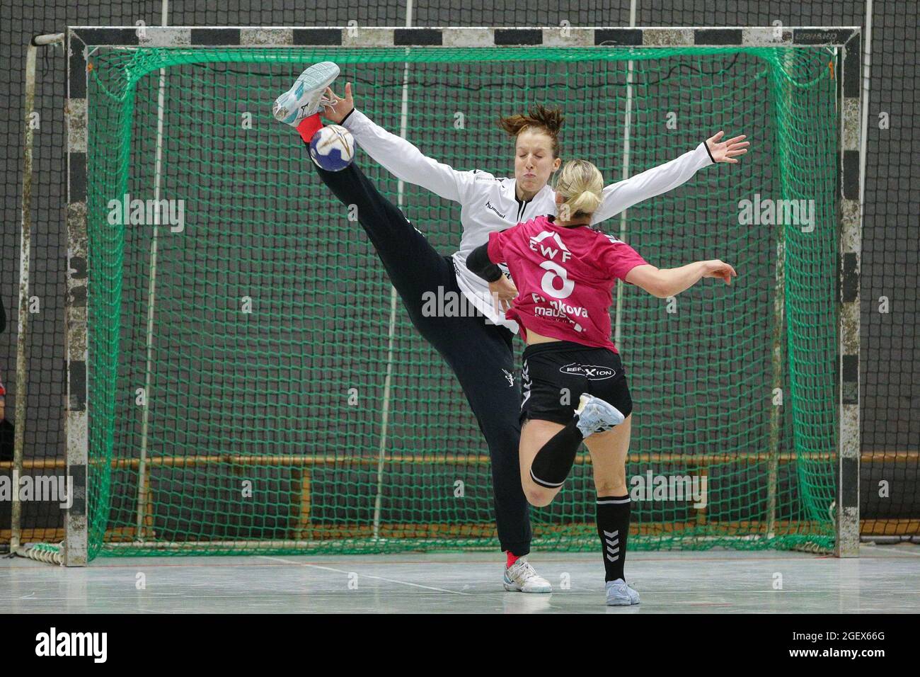 Torwartparade mit extremer Action. Handball-Torhüter mit Stand spaltet sich im Sprung gegen den Spieler. Stockfoto