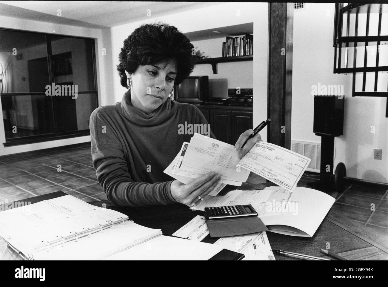 Austin Texas USA, um 1992: Frau, die zu Hause an Haushaltsbudgets arbeitet, nachdem sie ein persönliches Girokonto ausbalanciert hat. MR-EH0357 ©Bob Daemmrich Stockfoto