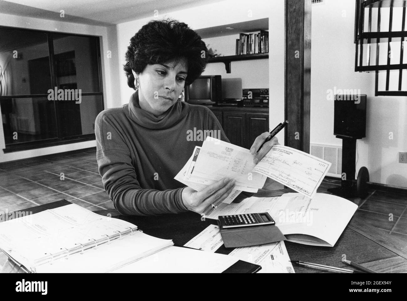 Austin Texas USA, um 1992: Frau, die zu Hause an Haushaltsbudgets arbeitet, nachdem sie ein persönliches Girokonto ausbalanciert hat. MR-EH0357 ©Bob Daemmrich Stockfoto