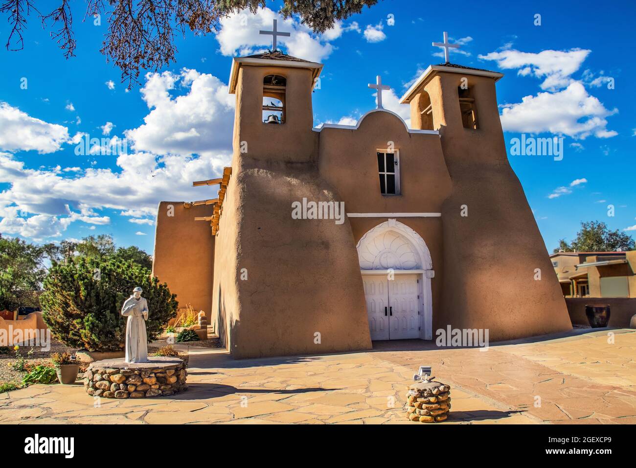 Historische adobe San Francisco de Asis Mission Church in Taos New Mexico in dramatischem späten Nachmittag Licht unter intensivem blauen Himmel mit flauschigen, während Wolke Stockfoto