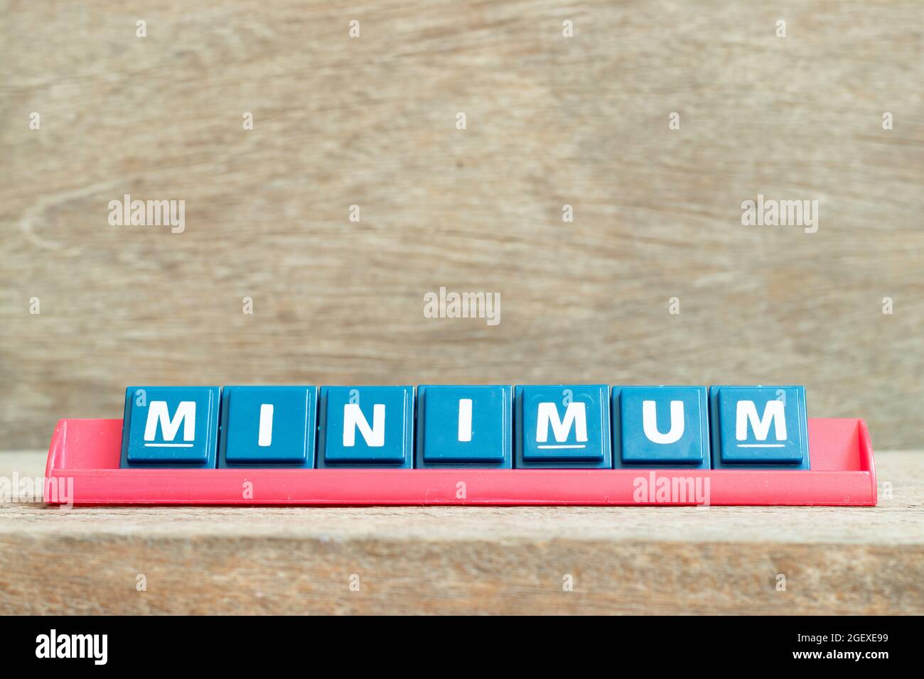 Fliesen Alphabet Buchstaben mit Wort Minimum in roter Farbe Rack auf Holz Hintergrund Stockfoto