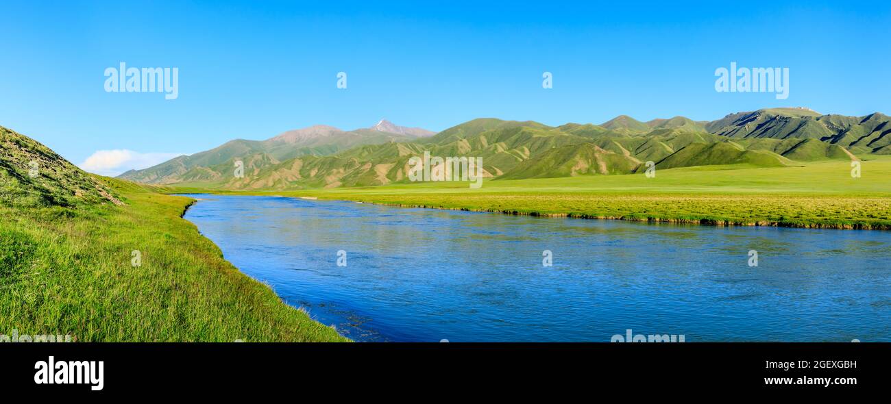 Grasland und Fluss mit Berglandschaft in Xinjiang, China. Stockfoto