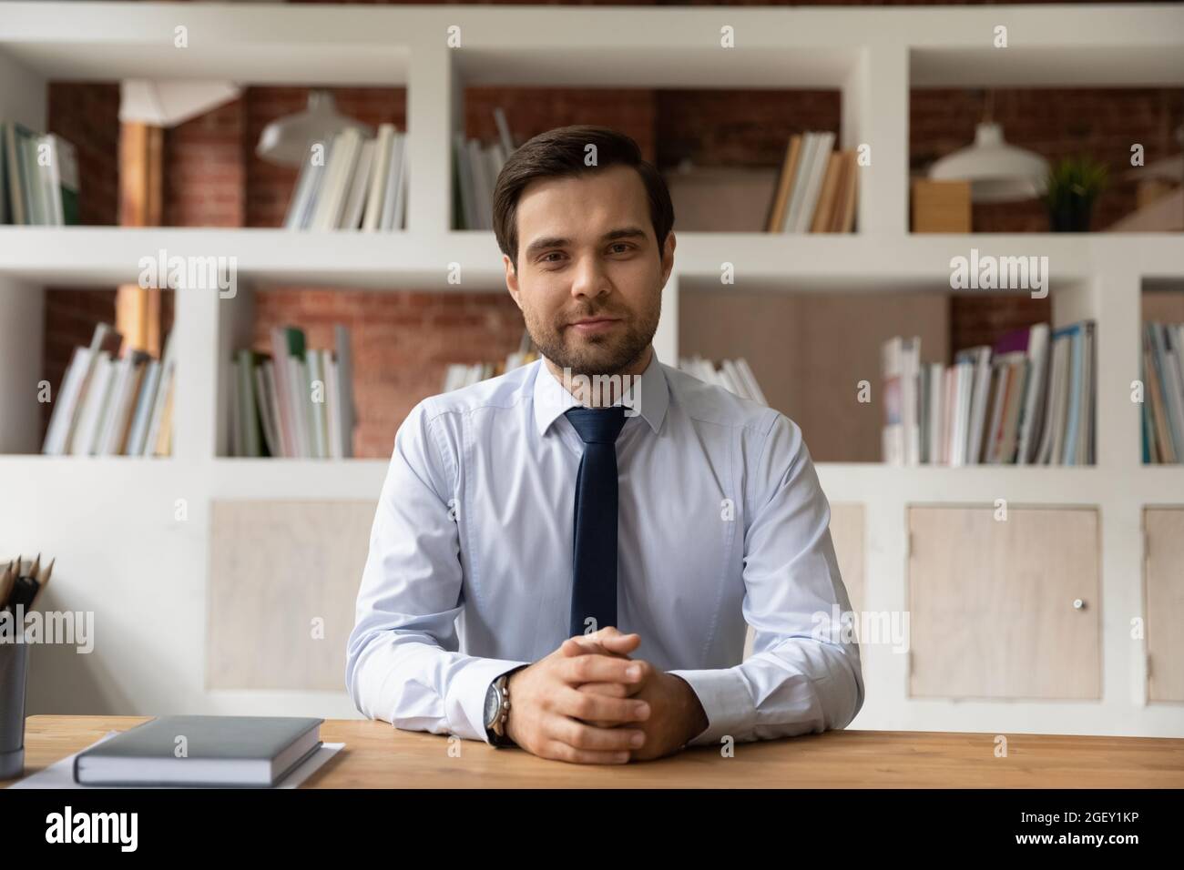 Porträt eines intelligenten Geschäftsführers, der am Schreibtisch sitzt Stockfoto