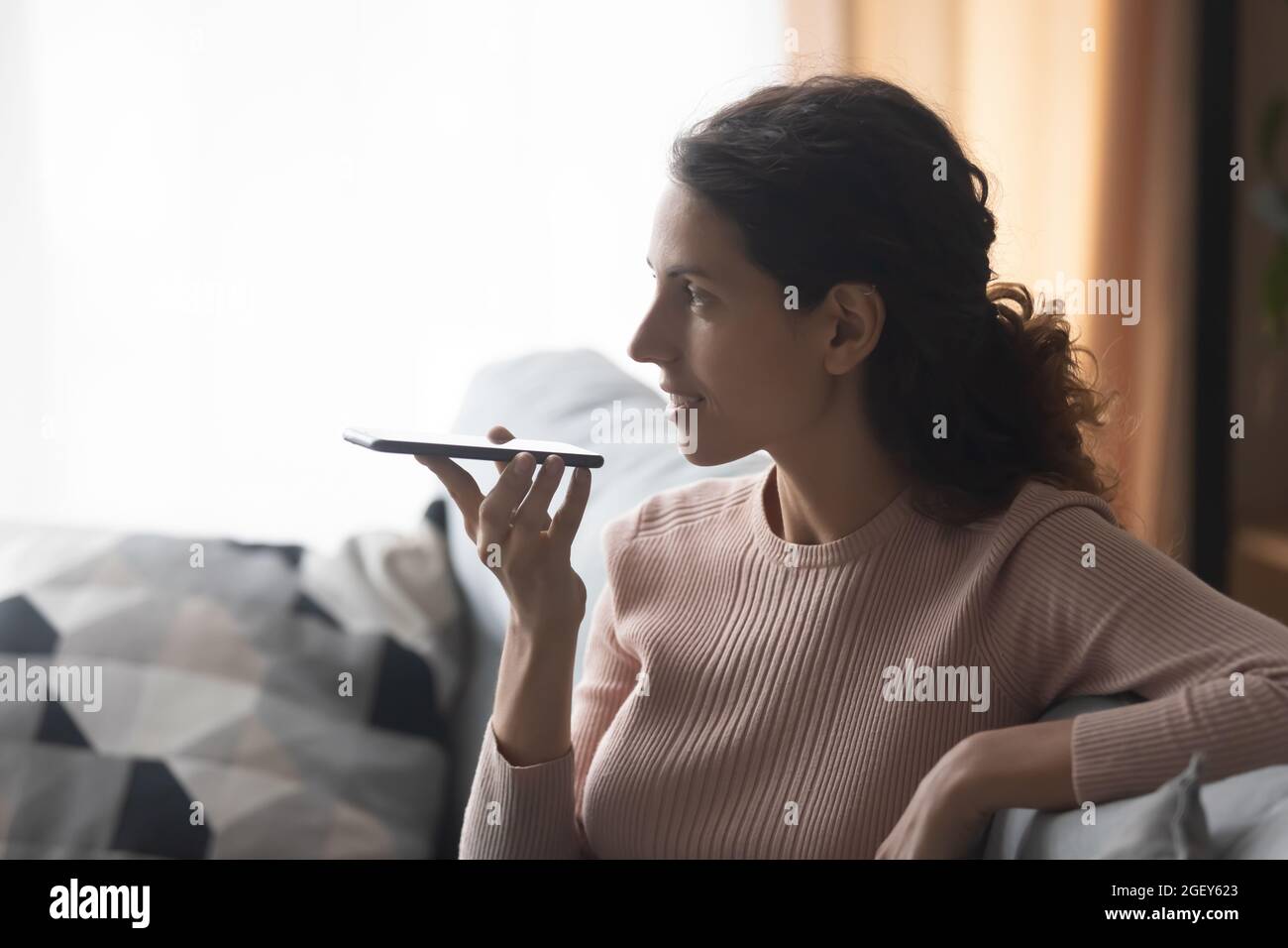 Latina-Frau hält Mobiltelefon Sprechen Sie mit einem Freund über einen Lautsprecher Stockfoto